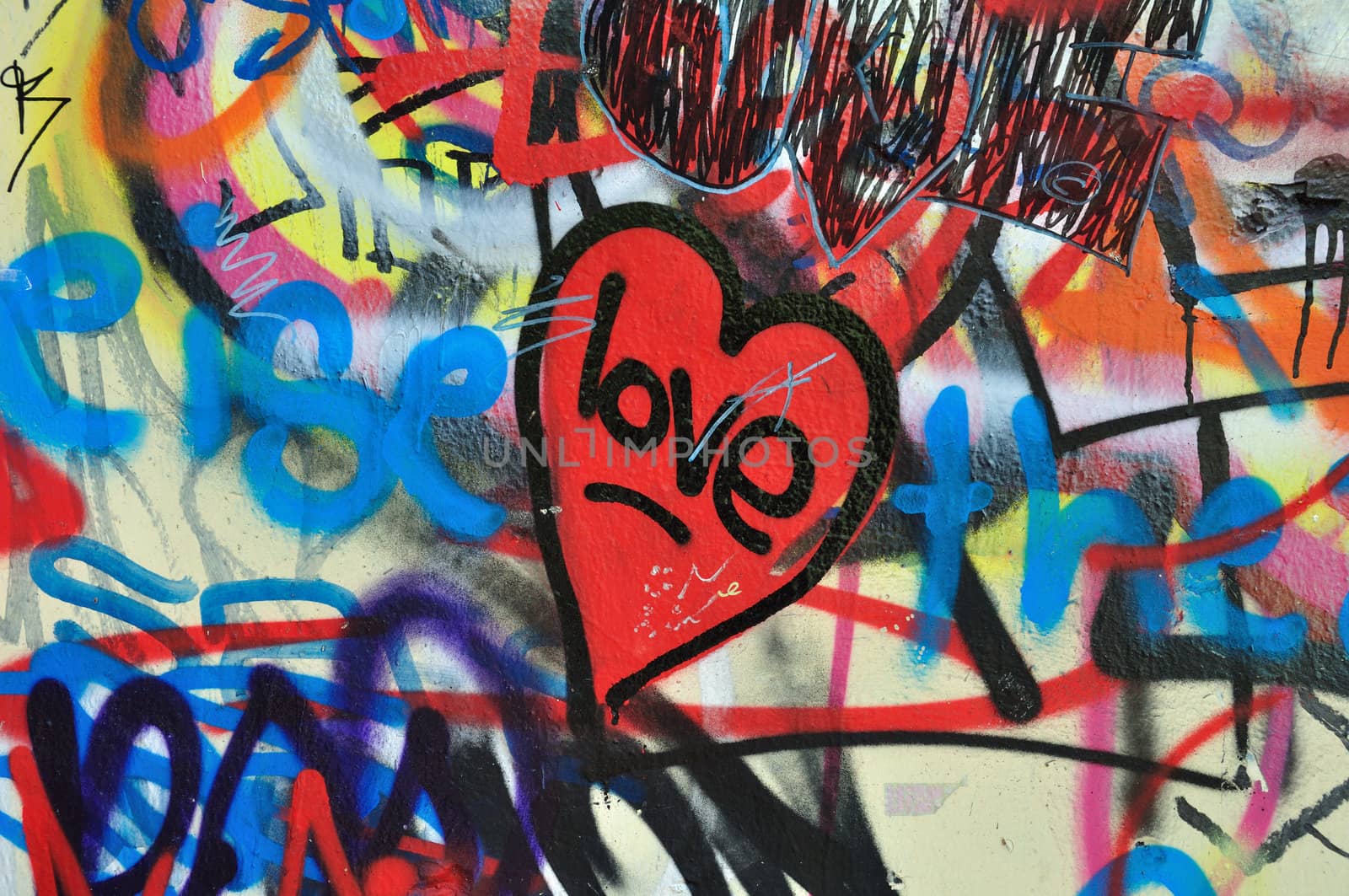 Painted heart on messy smudged wall background. Love graffiti detail.