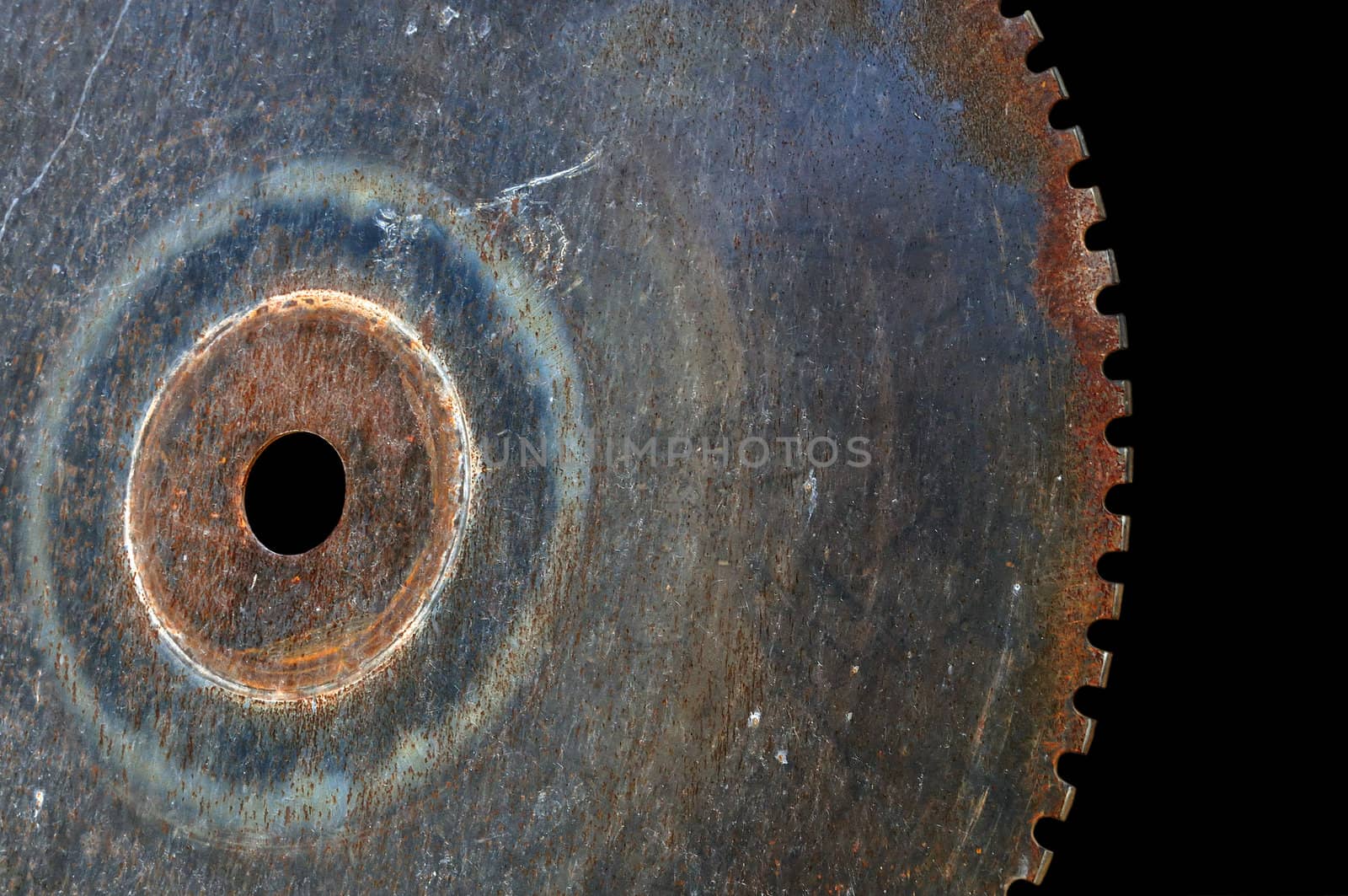 Rusty saw blade cutting wheel. Vintage industrial equipment on black background.
