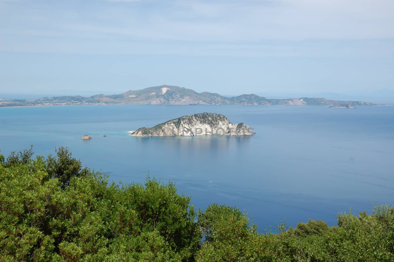 Small island sea and sky horizon landscape. Marathonisi islet, Zakynthos, Greece.