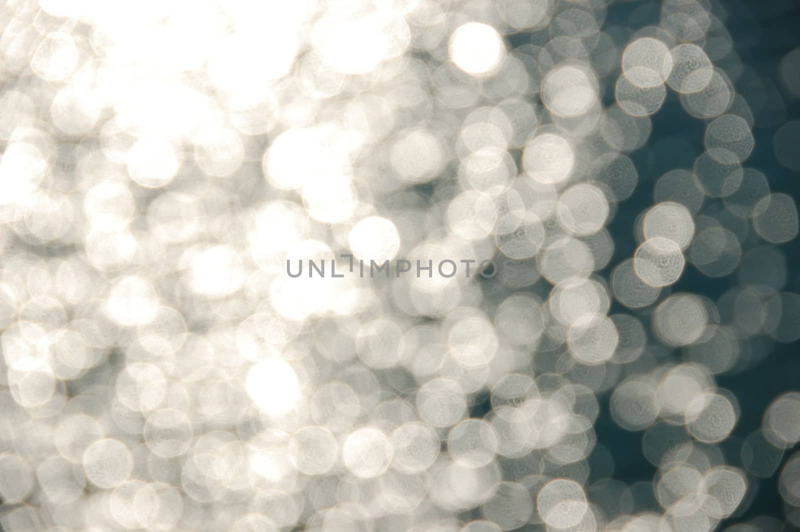 Light shining on sea water. Blurry reflections on sunny day abstract background.