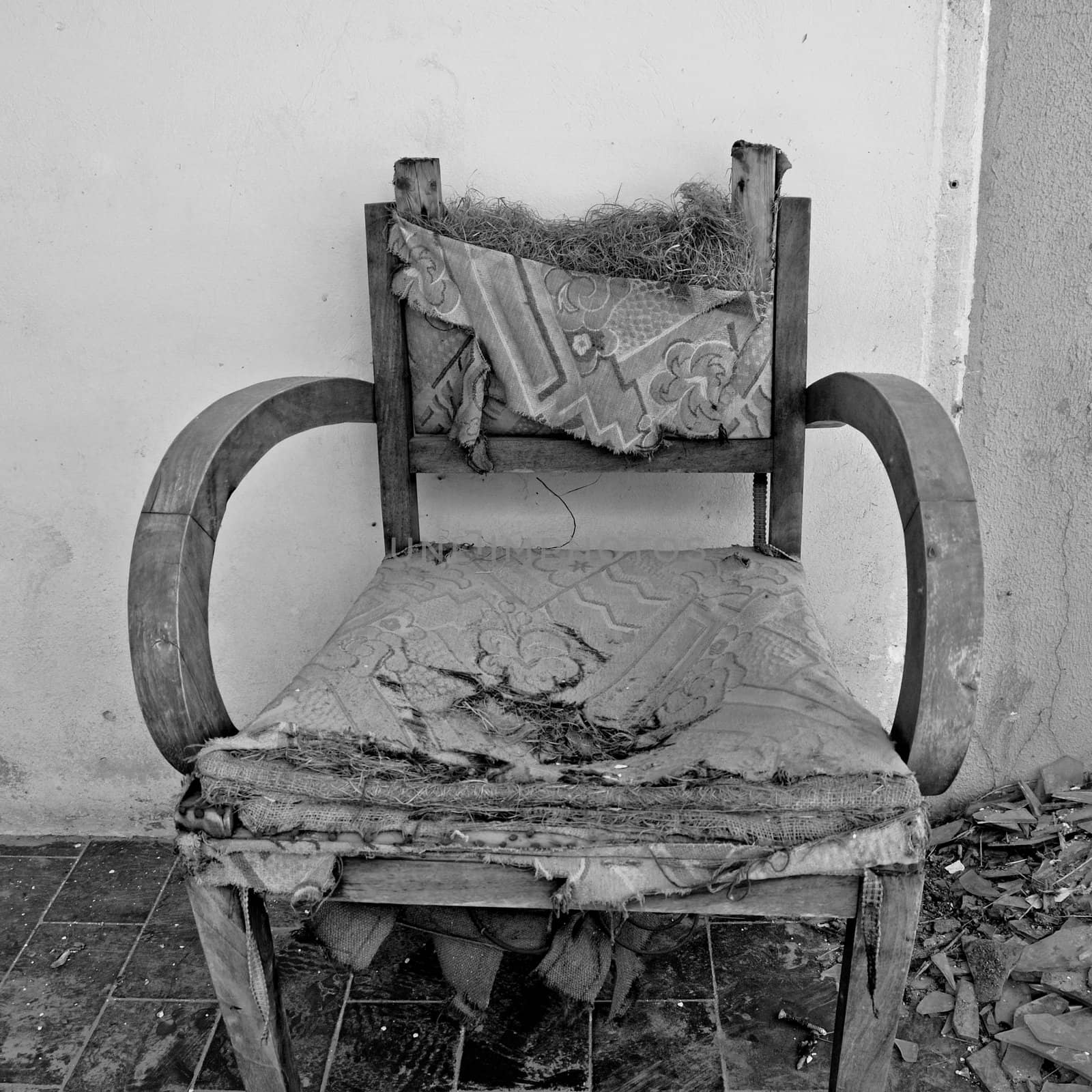 Torn armchair and pile of broken glass. Black and white.