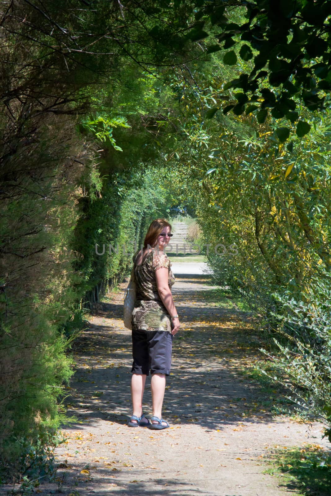 A Woman Looking Back through a tree tunnel