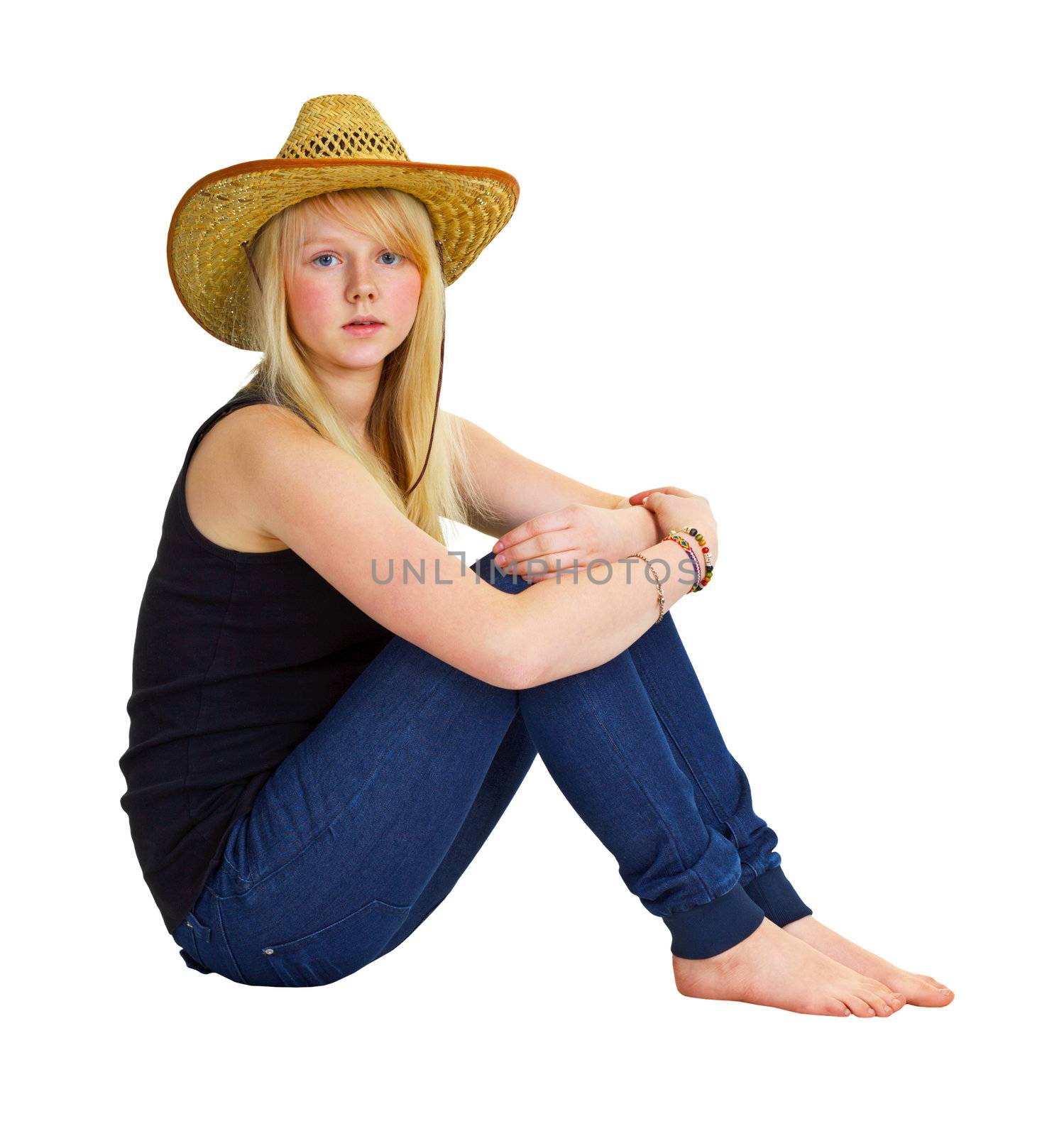 A young girl in a farmer dress sitting isolated on white background