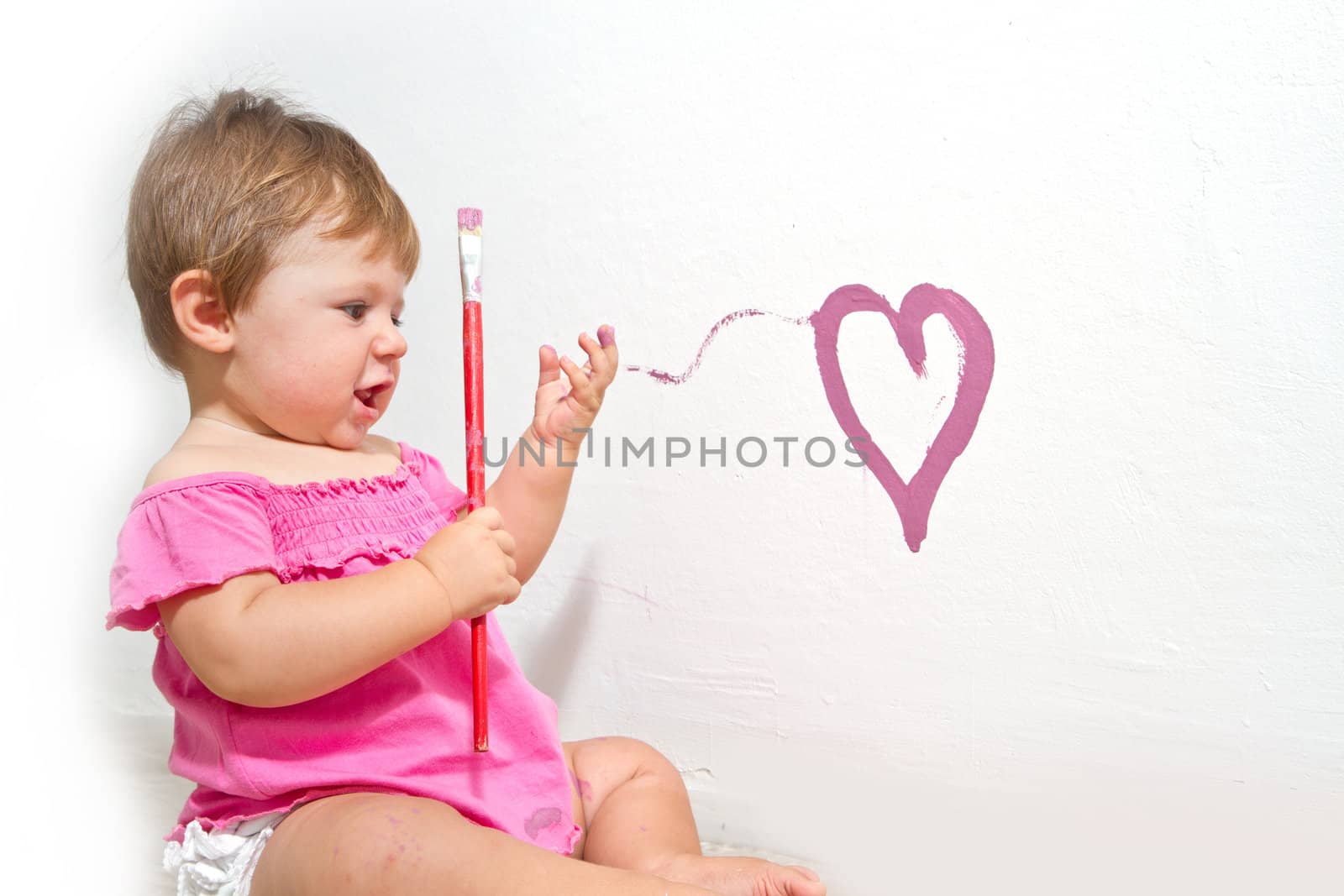 Little girl paint on a board