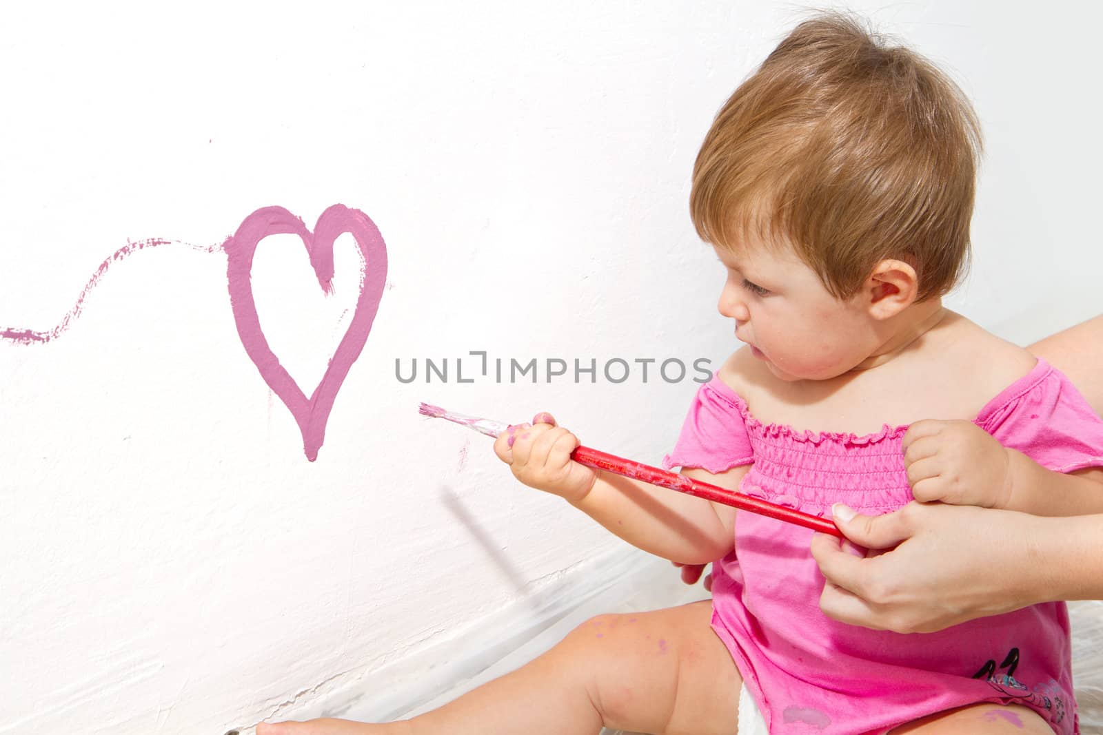 Little girl paint on a board