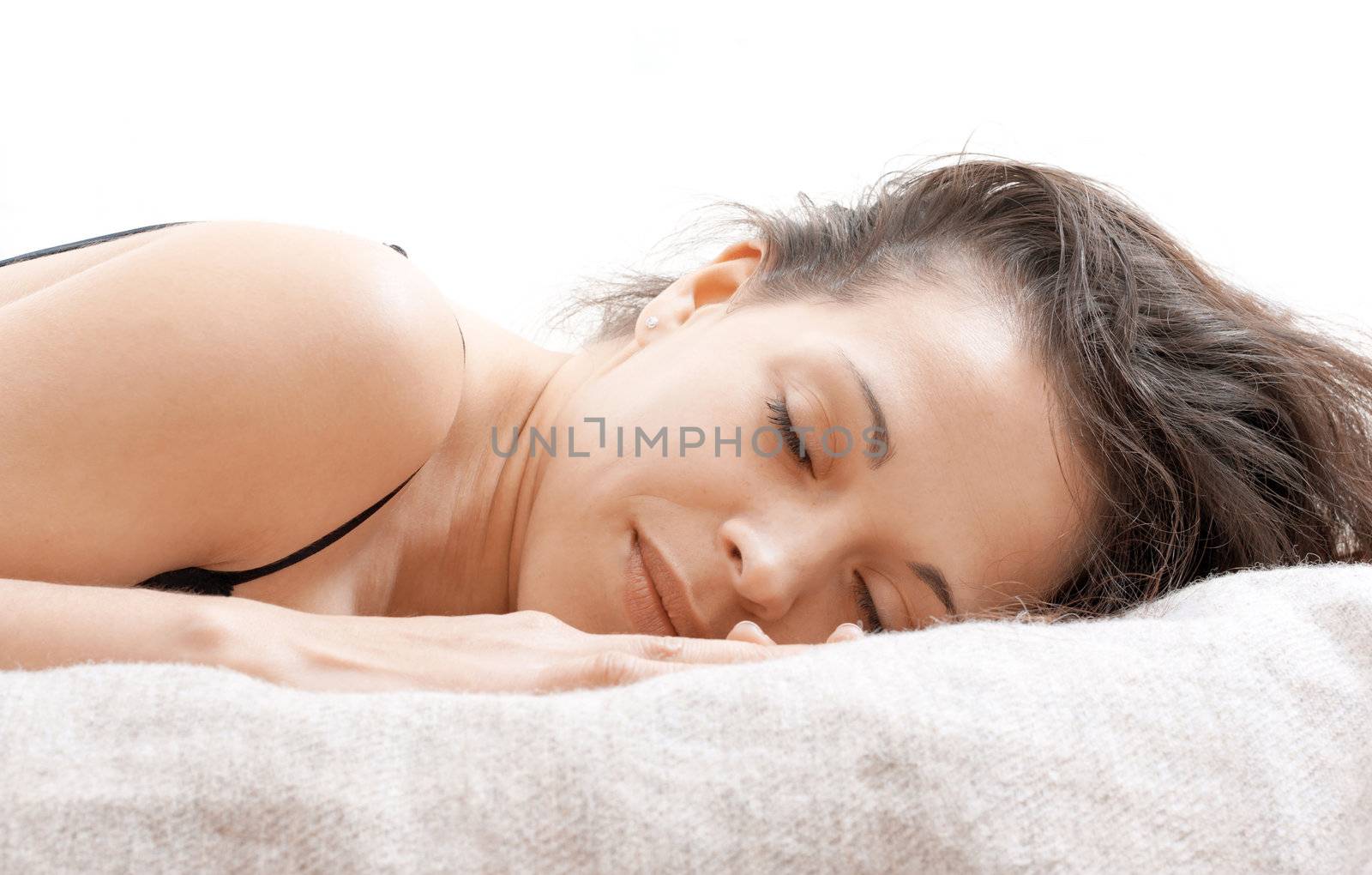 A woman lying on a bed with a rested face 