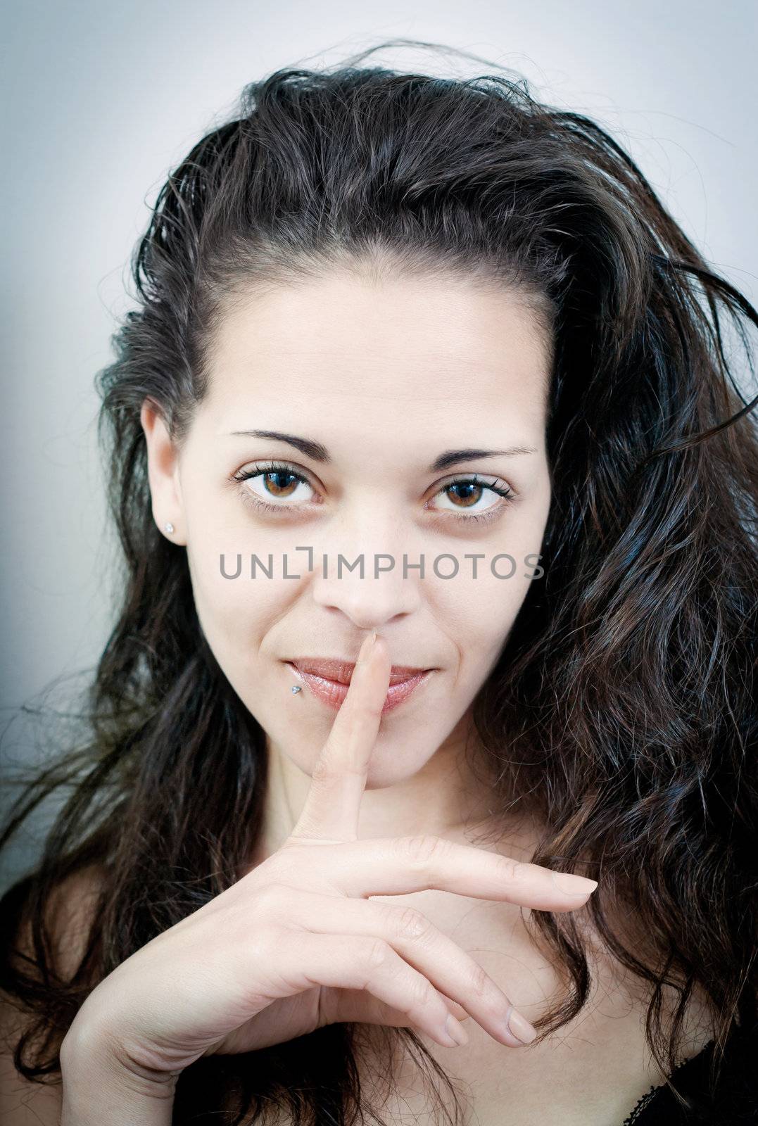 Sensual young woman with her finger on her lips