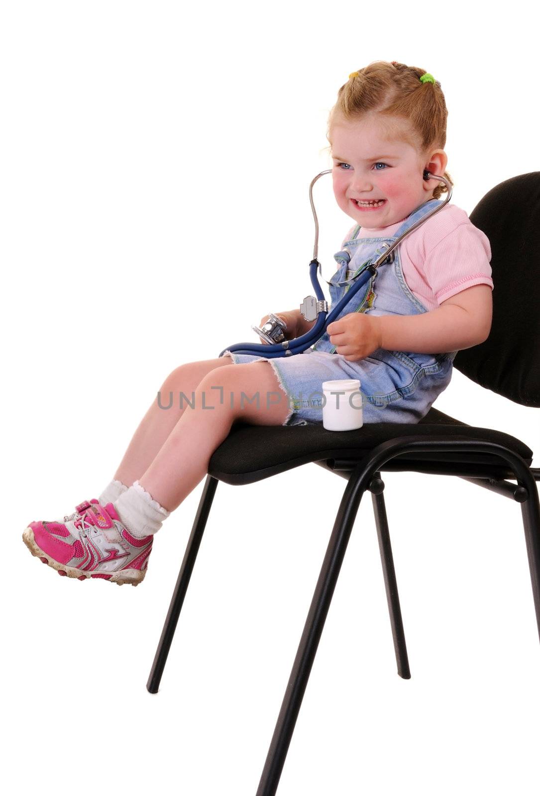 Small playful girl on chair with stethoscope isolated on white background