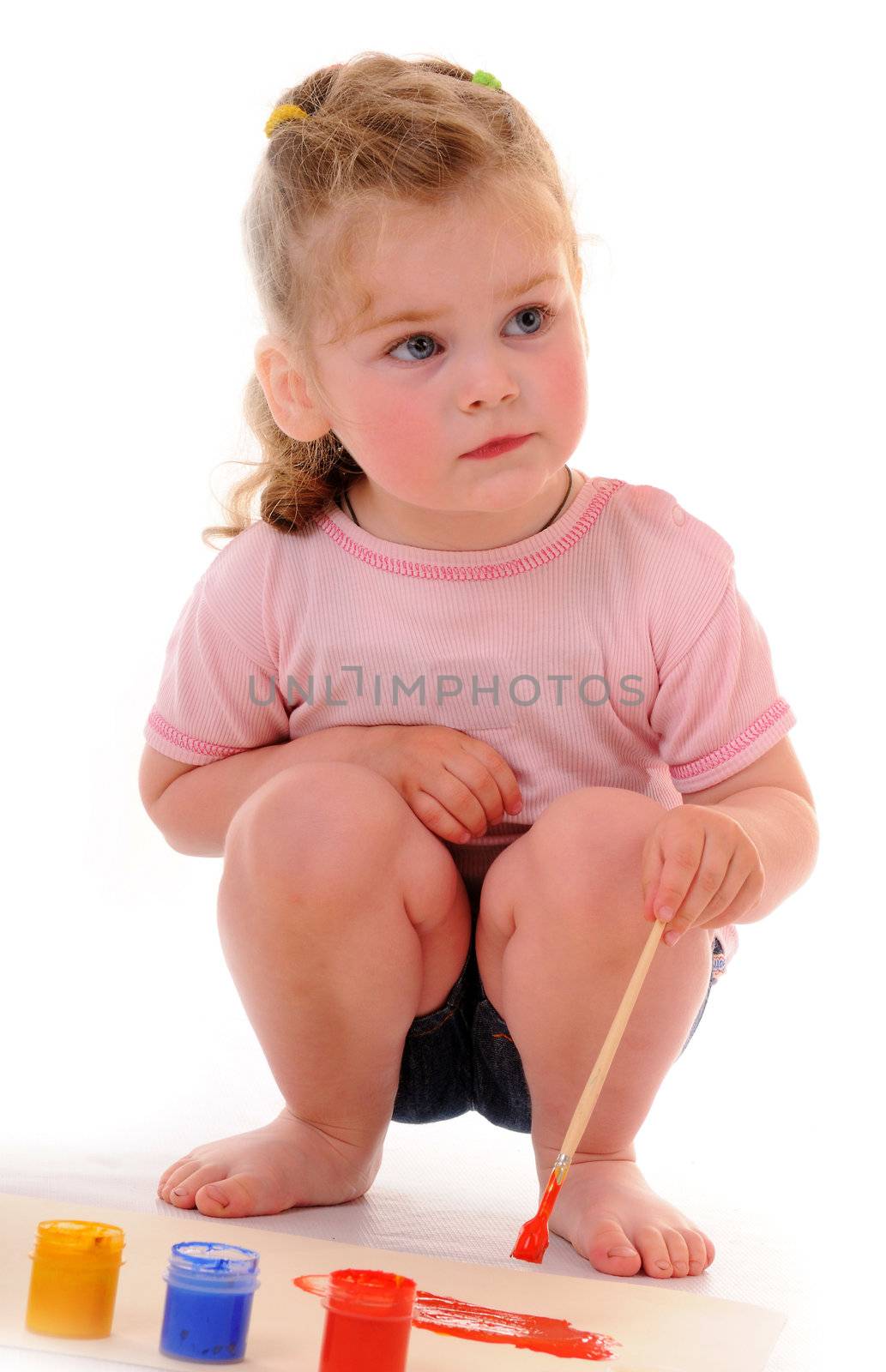 Small blonde girl with paintbrush and paints