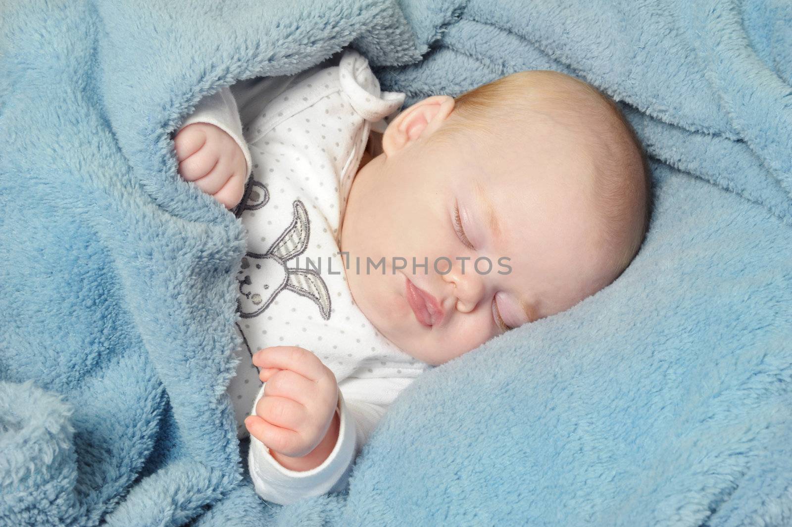 Adorable little baby sleeping peacefully on a blanket