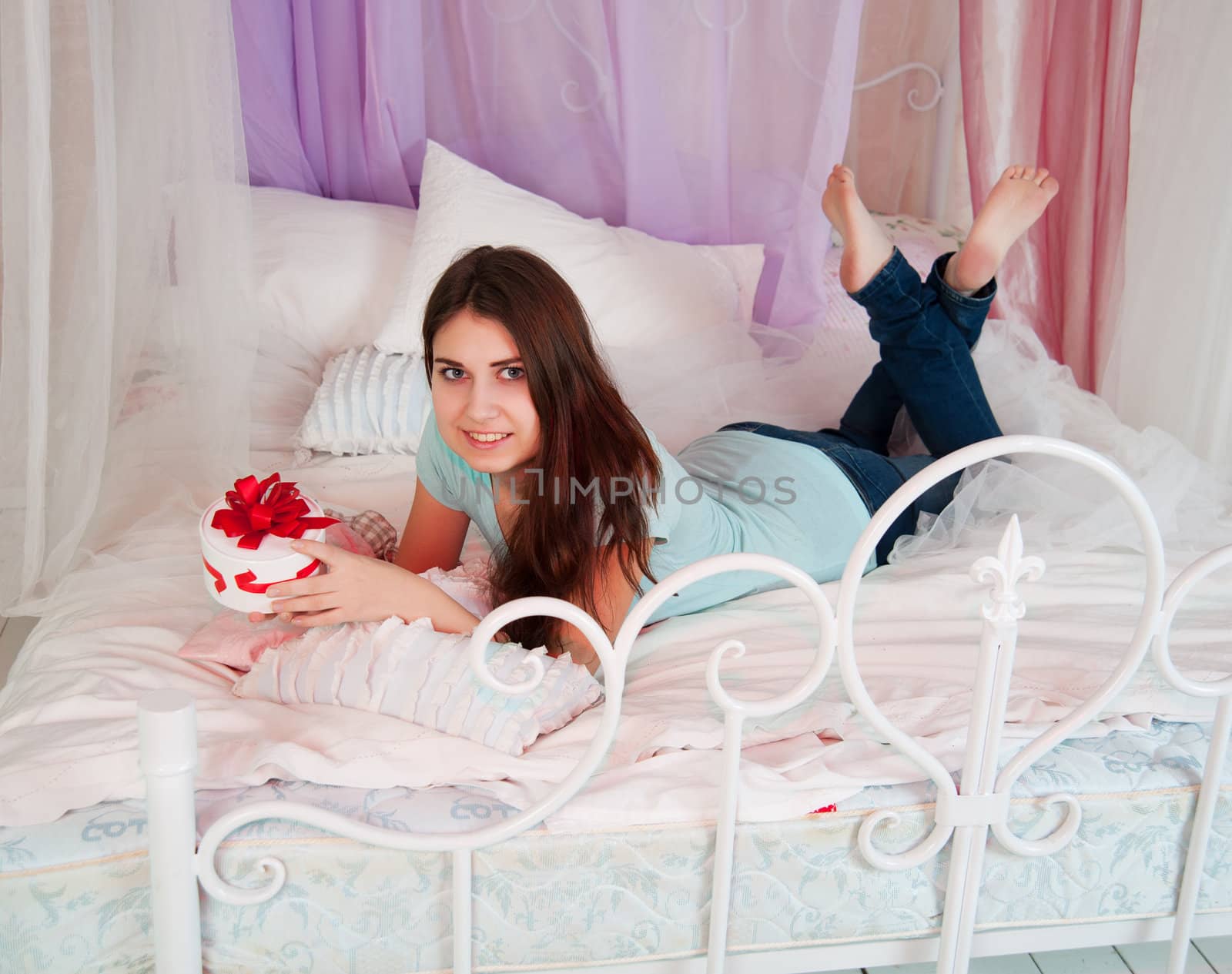 Beautiful woman in bed opening a gift