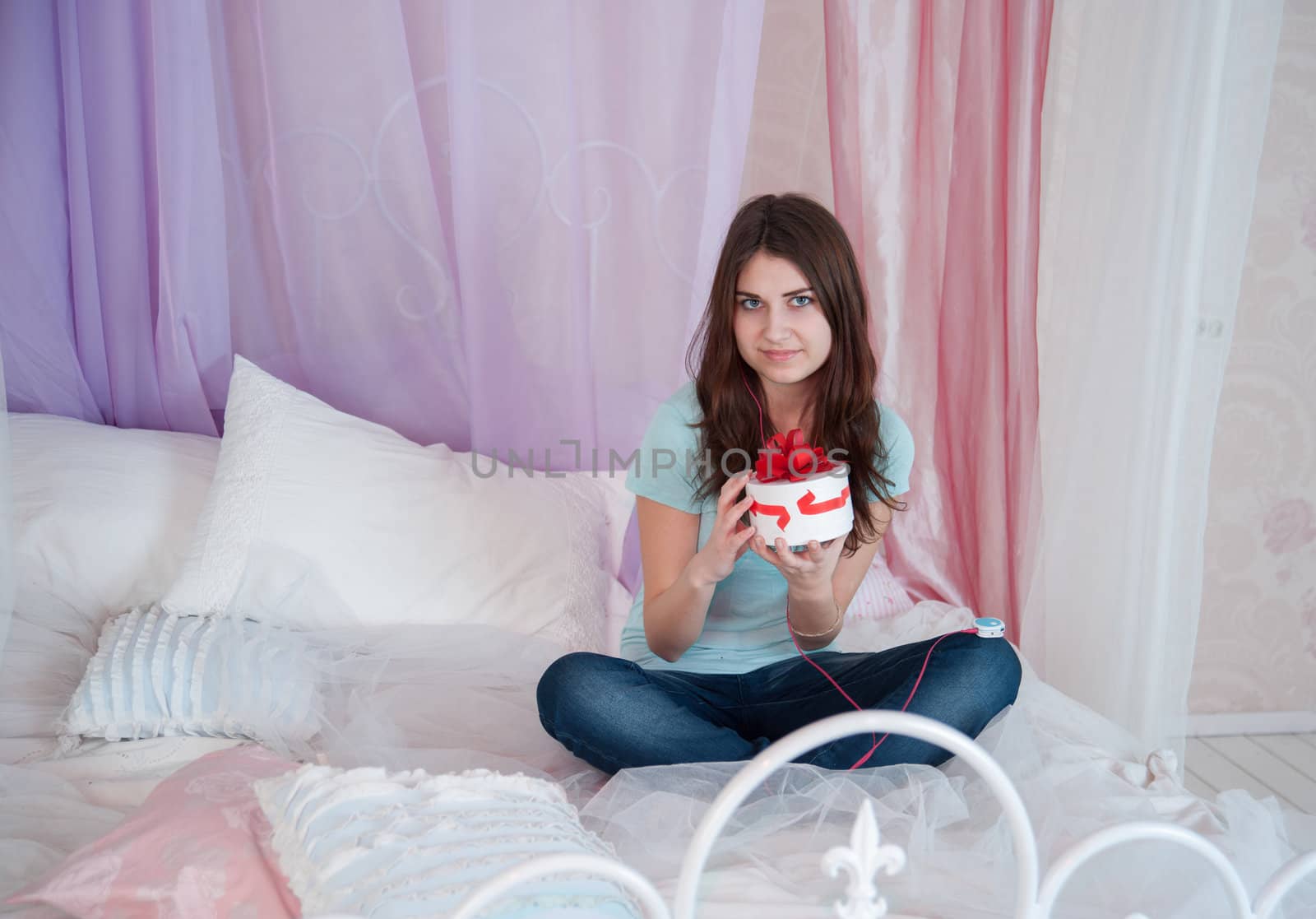 Beautiful woman in bed opening a gift