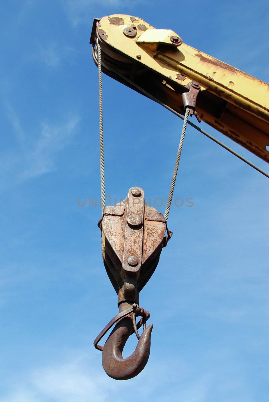 Hook of an old crane against a blue sky
