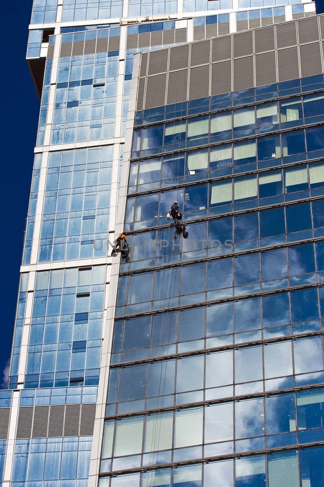 Two men cleaning windows of a skyscraper