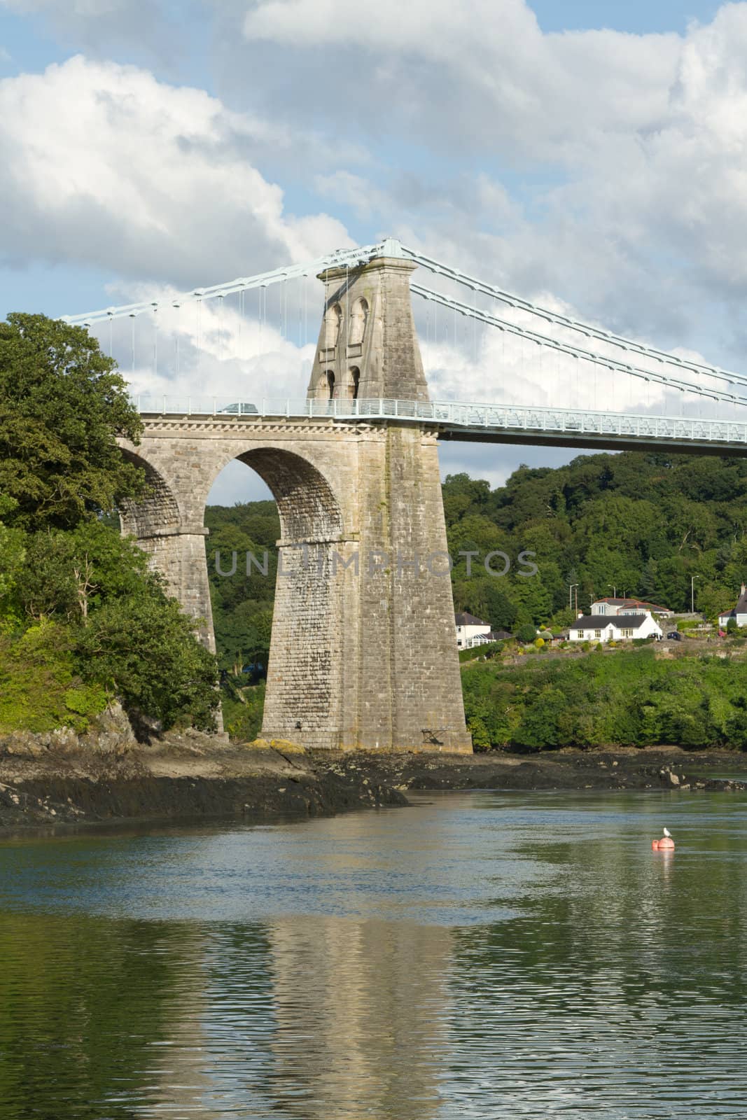 A tower and arch of the historic Menai Suspension bridge over the Menai Straits, Gwynnedd, Wales, UK.