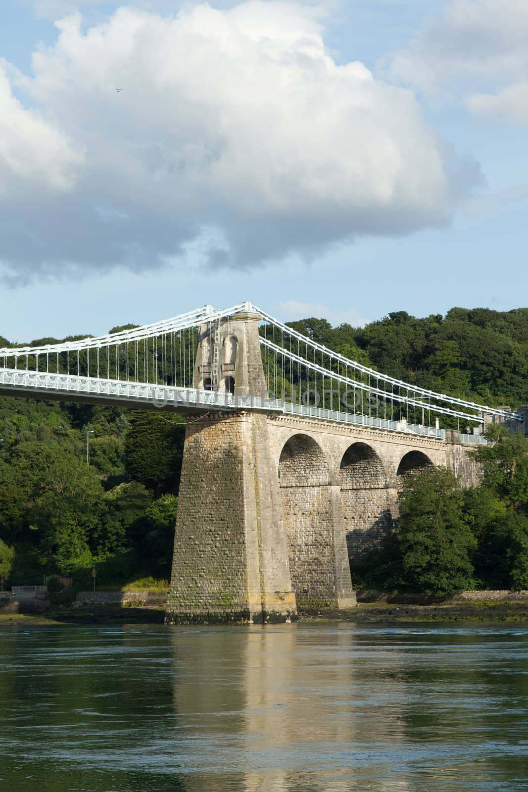 A tower and arches of the historic Menai Suspension bridge over the Menai Straits, Gwynnedd, Wales, UK.