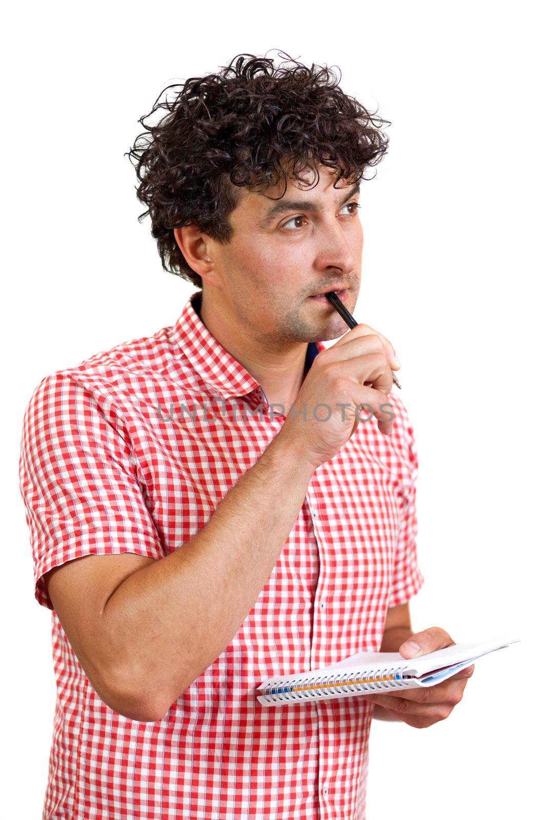 Young man looking thoughtful, holding a pencil and notebook, isolated on white background