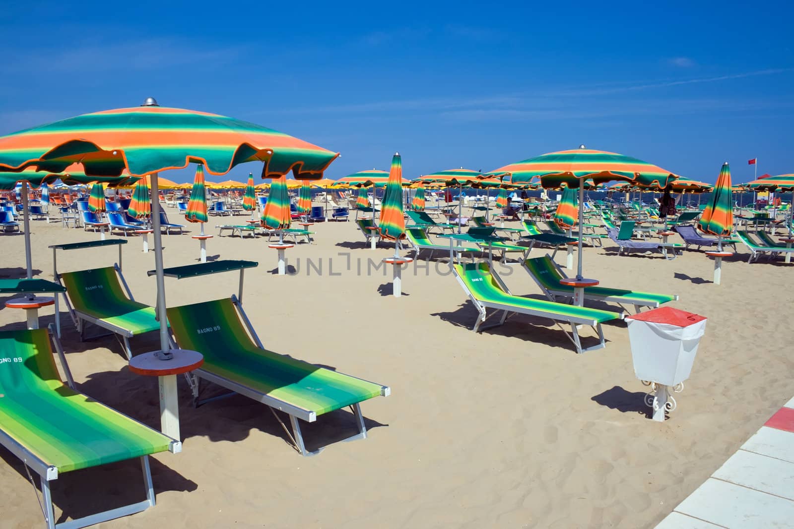 chaise longue and umbrellas on a sandy beach in Rimini, Italy