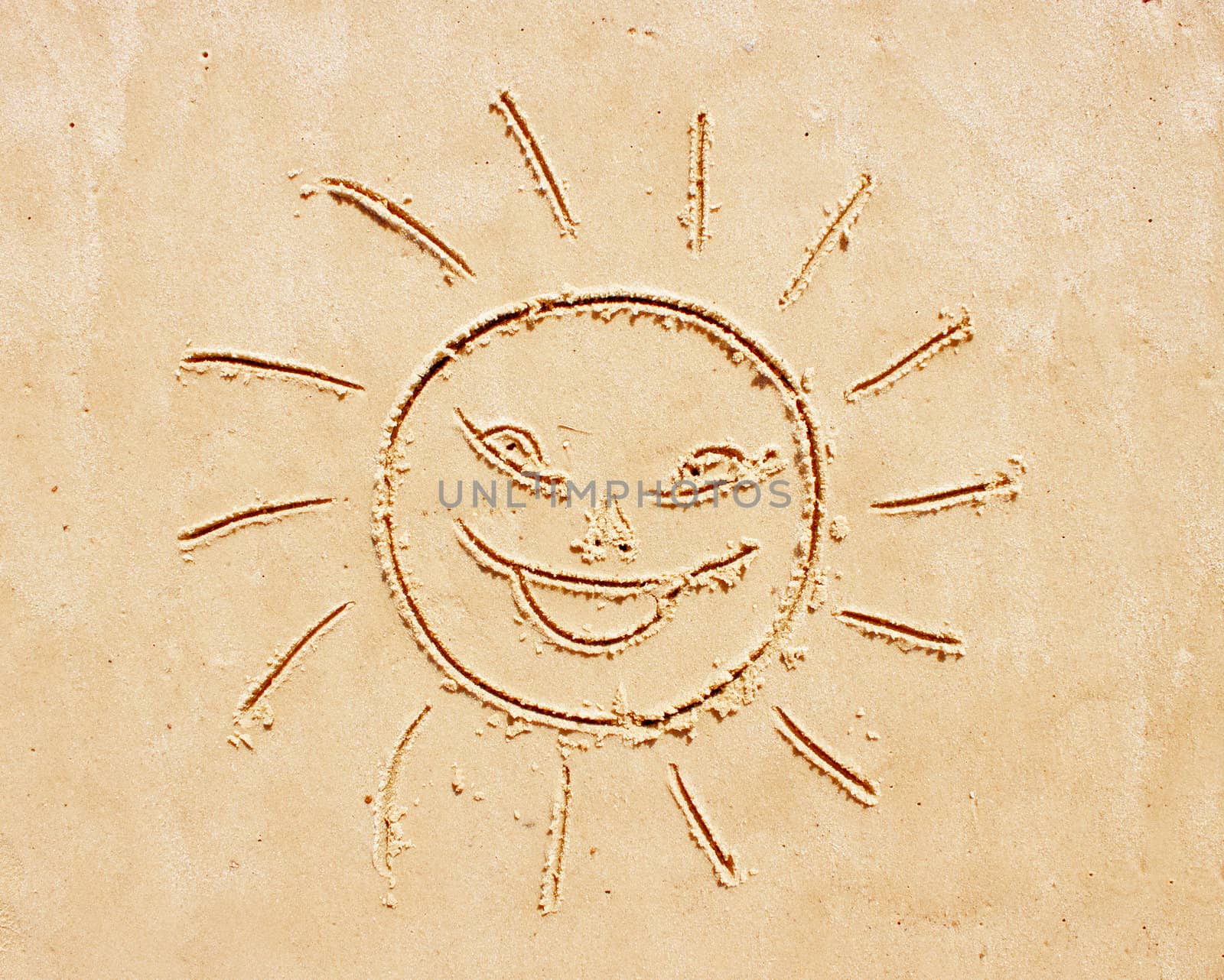 Smiling sun. Drawing of the child on sand