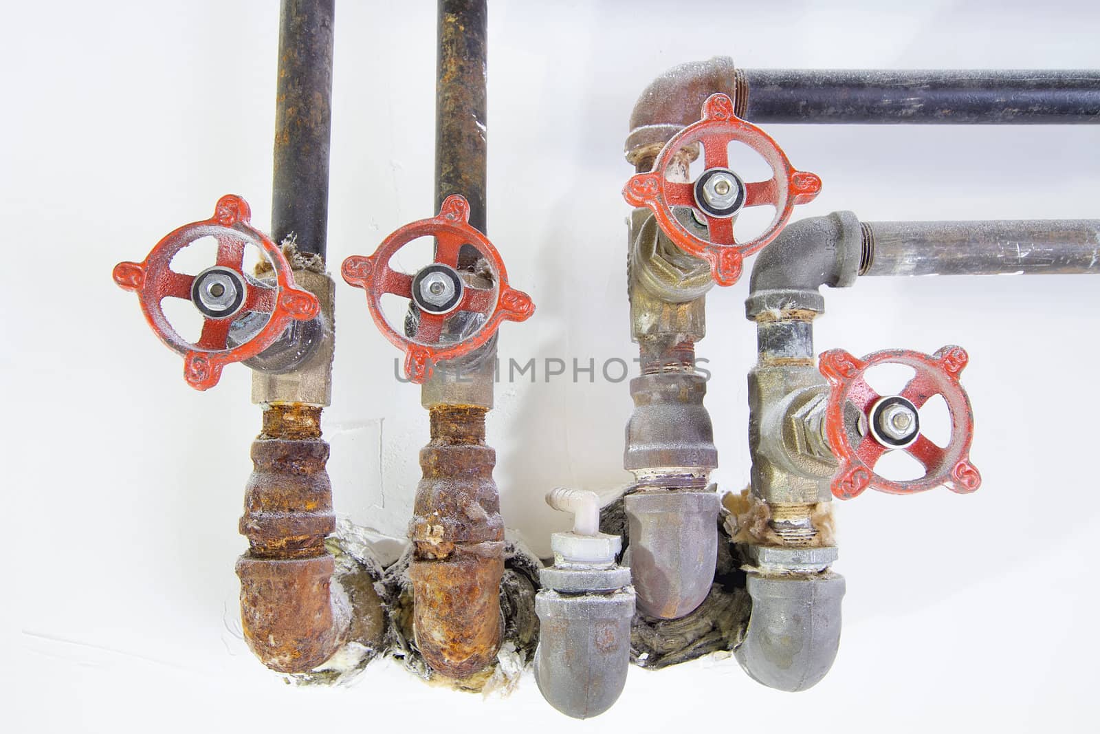 Old Plumbing Pipes with Valves Closeup Front by jpldesigns