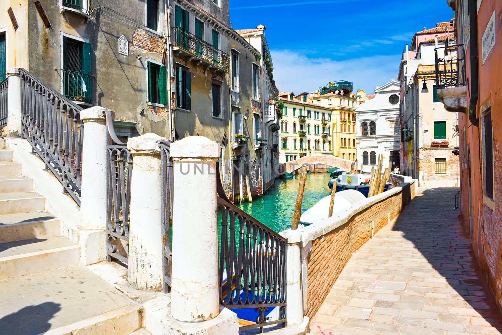 Small bridge over greenish water of a venetian canal, Italy