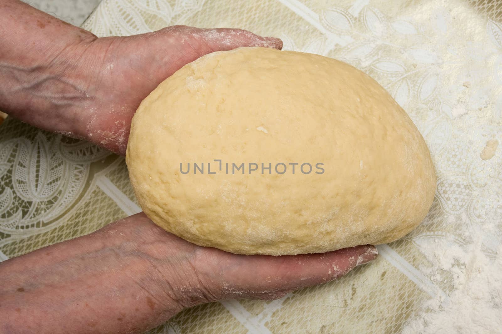 Hands of old woman making dough