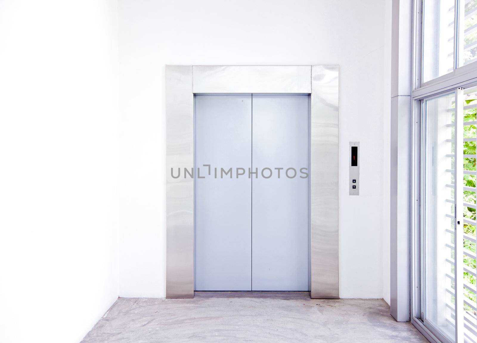 Front view of a modern elevator with closed doors in lobby