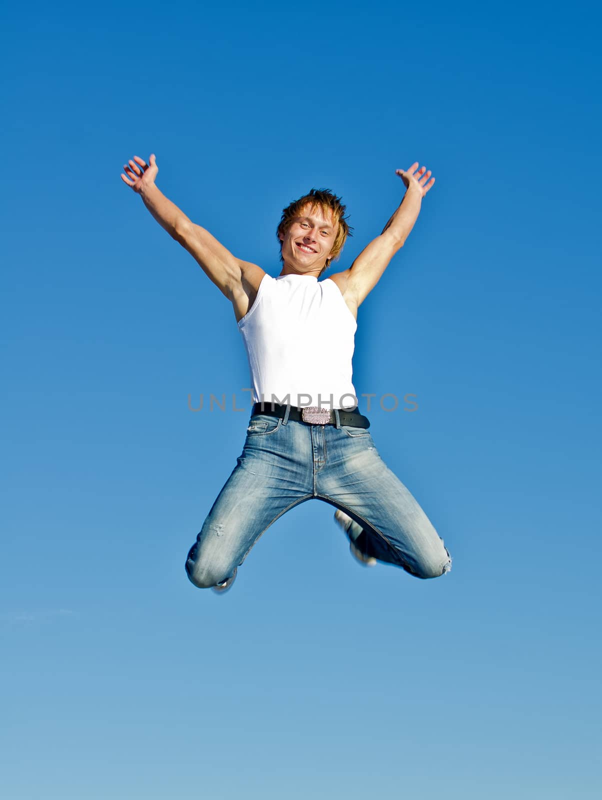 Happy jumping man on blue sky background