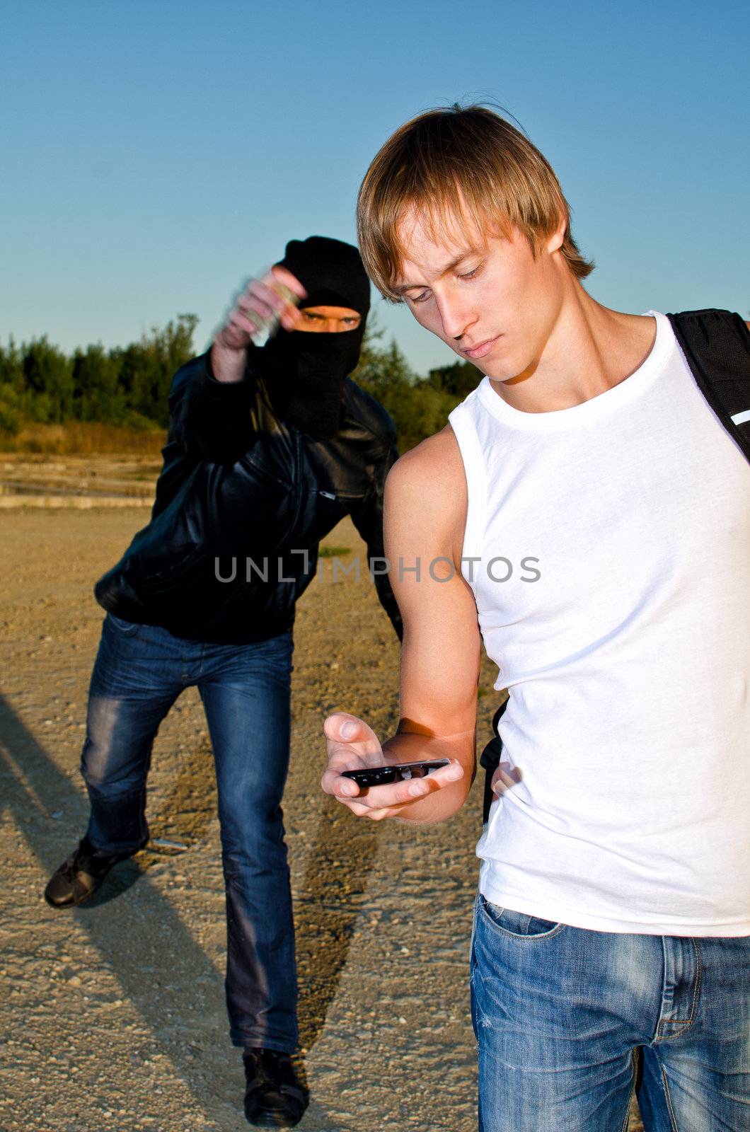 Bandit in mask trying to rob young man