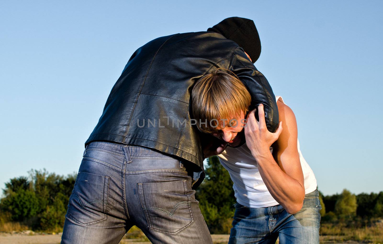 Two men fight outdoors. Robbery concept