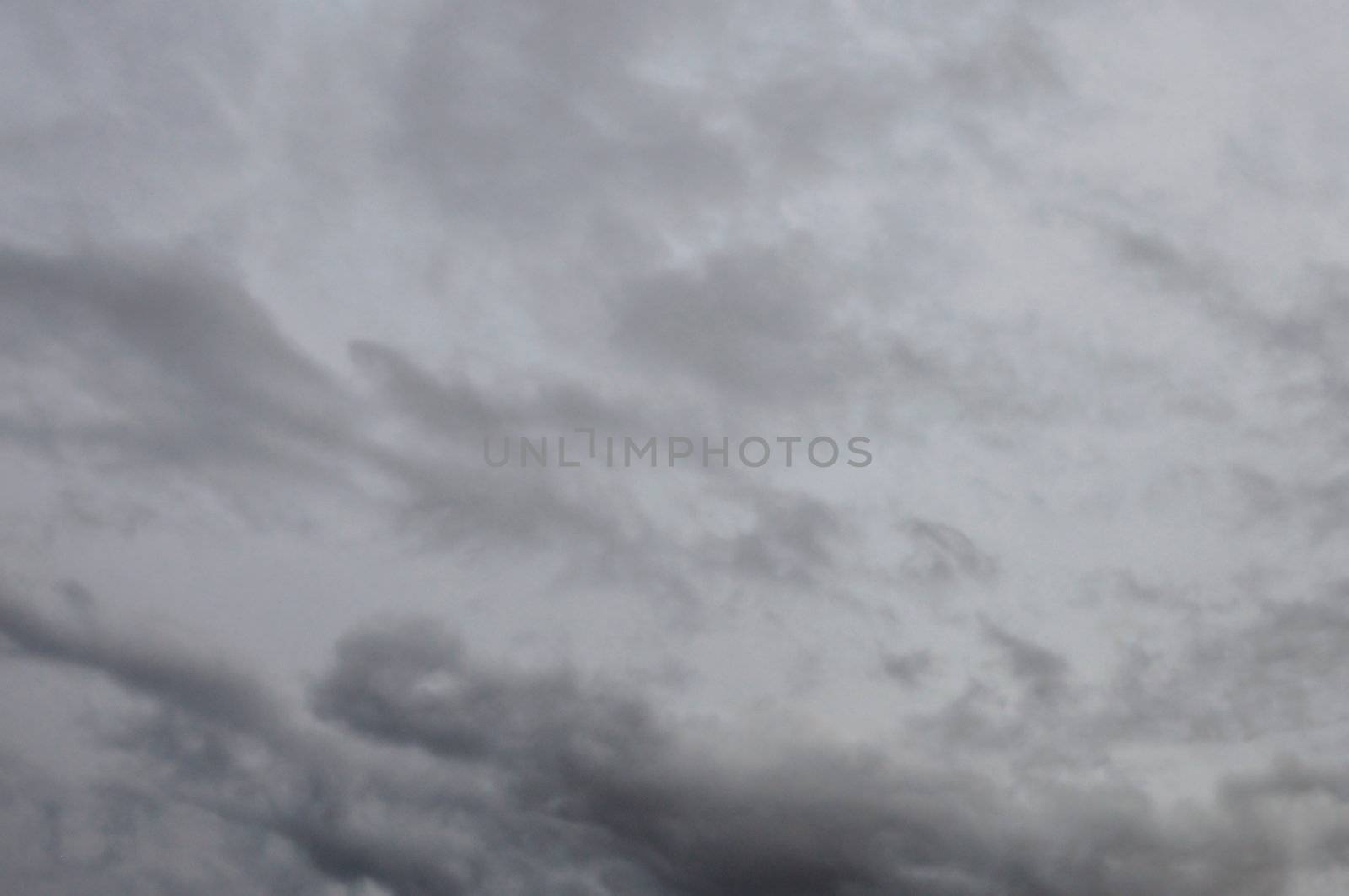 Black clouds against gray rainy winter sky. Nature background.