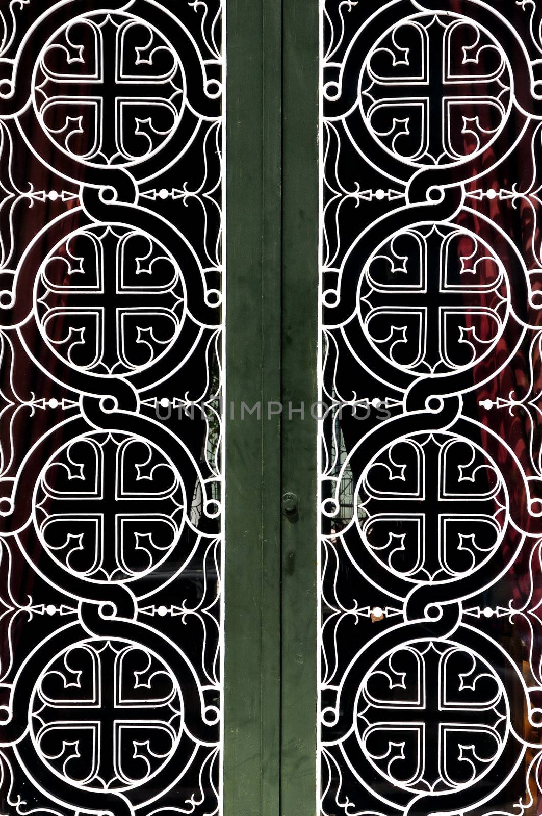 Tangled circles and cross christian religious icon pattern detail on iron church door.