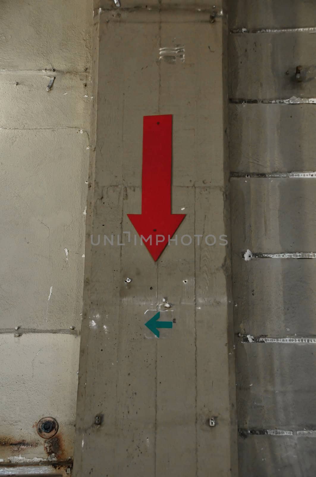 Concrete factory wall and arrow signs. Industrial background.