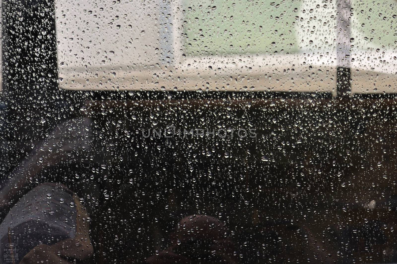 Raindrops on car window glass surface. Weather abstract background.