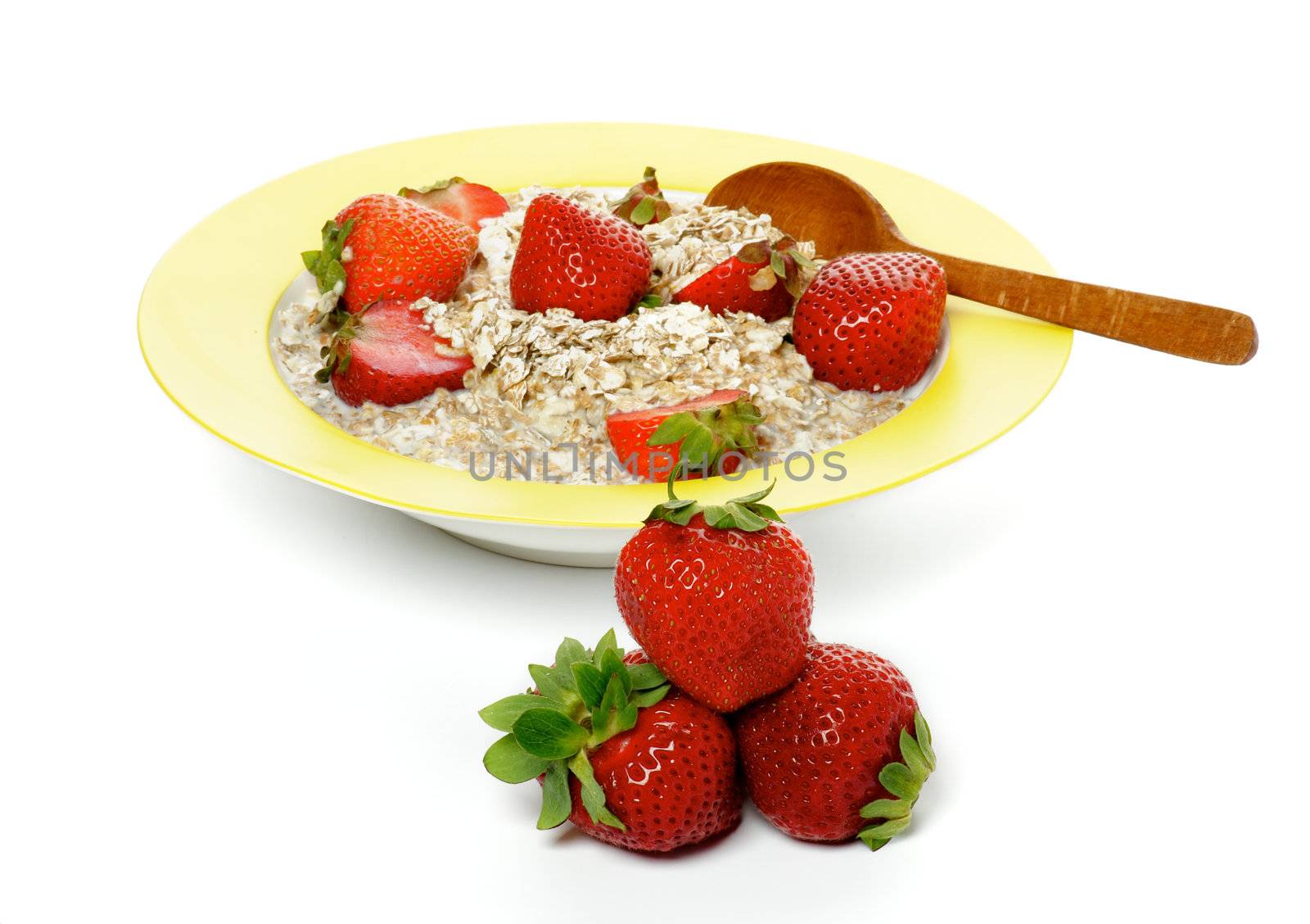 Healthy Muesli, Milk and Fresh Strawberry on Yellow plate with Wooden Spoon isolated on white background