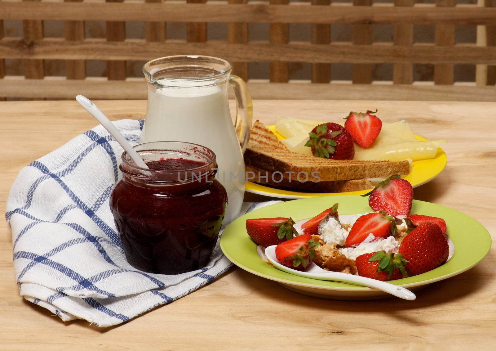Village Breakfast of Toasts, Strawberries, Jam, Milk and Curds close up on wooden background