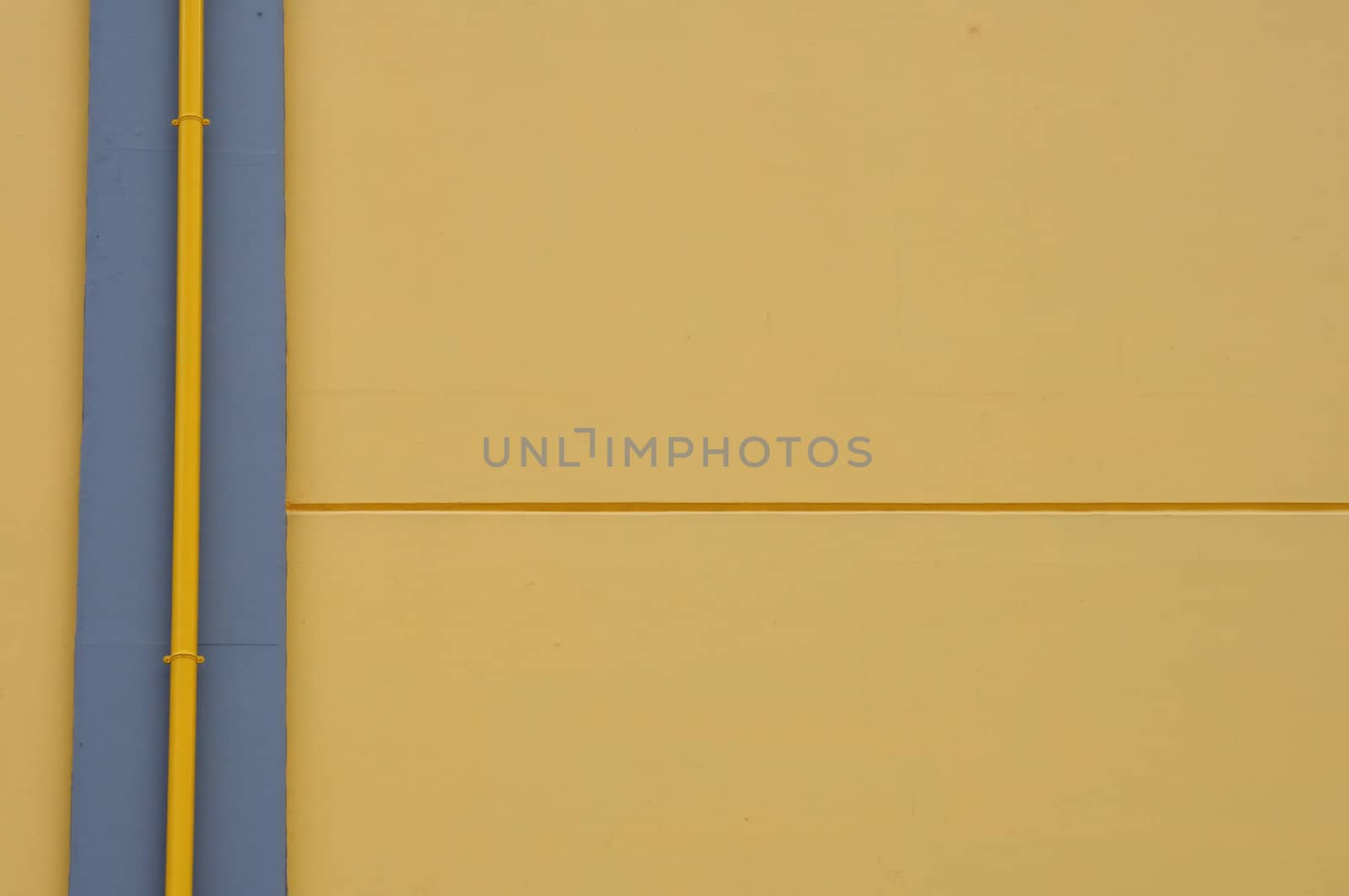 Yellow wall and drain pipe background. Abstract architectural detail.