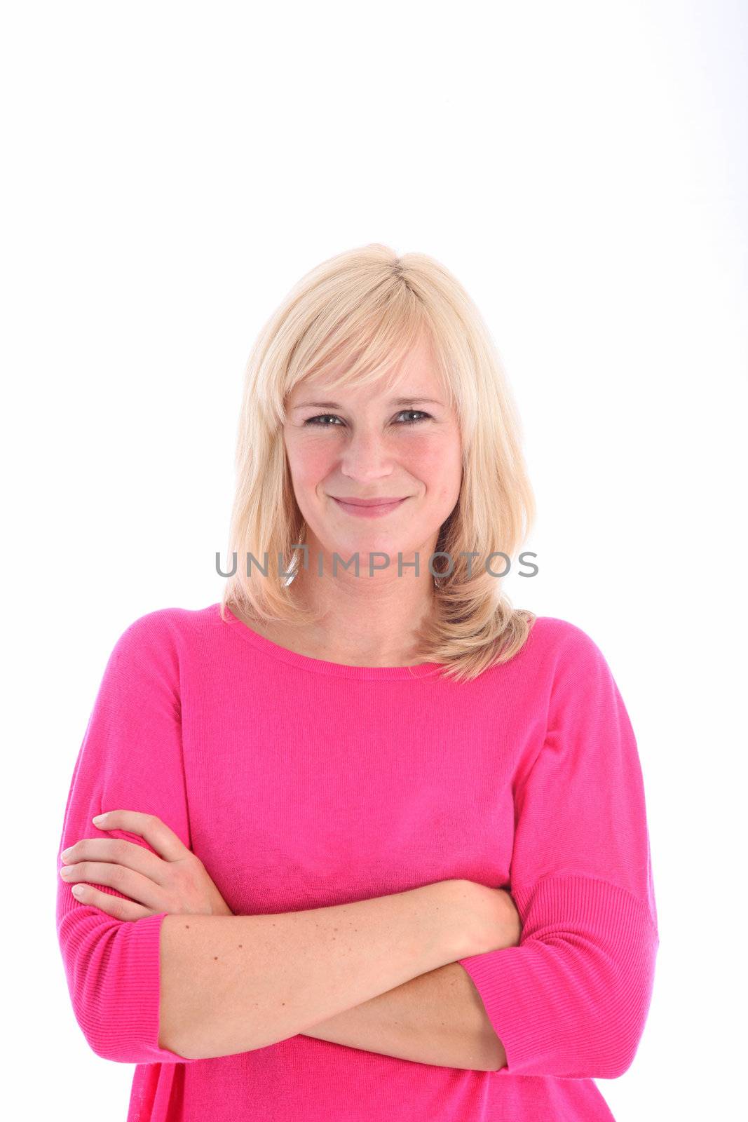 Smiling blonde woman with arms folded posing on white background 