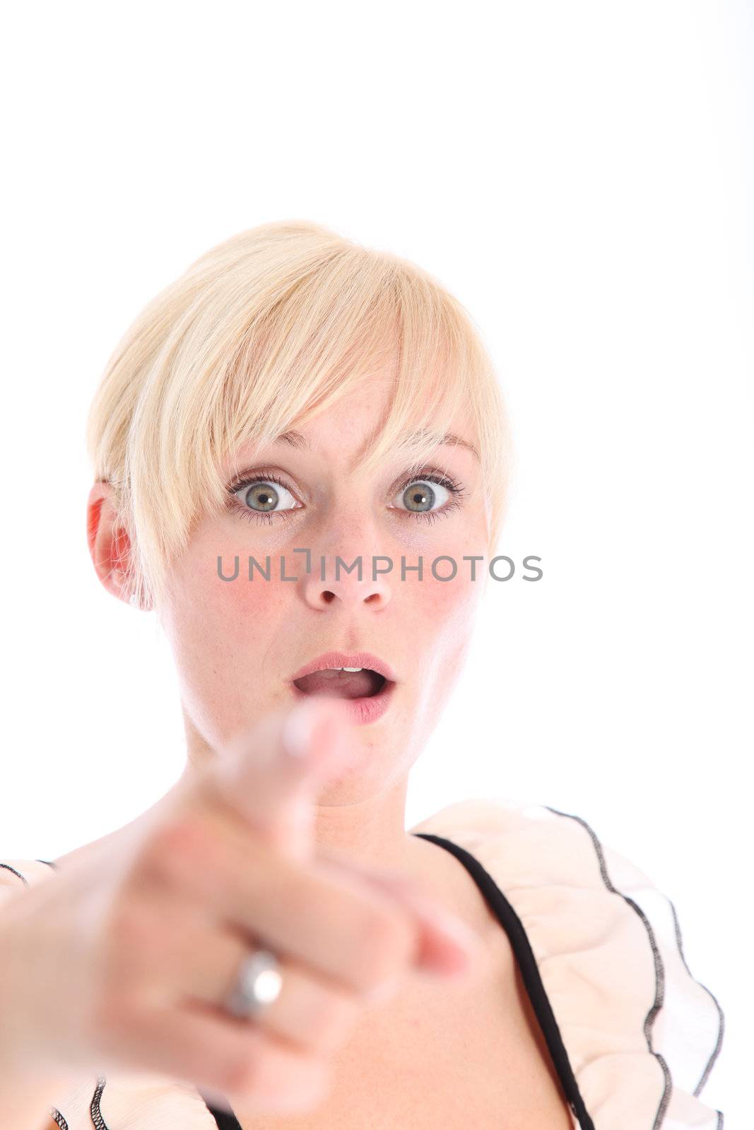Woman pointing her finger at the camera with look of amazement on her face with focus to her head 