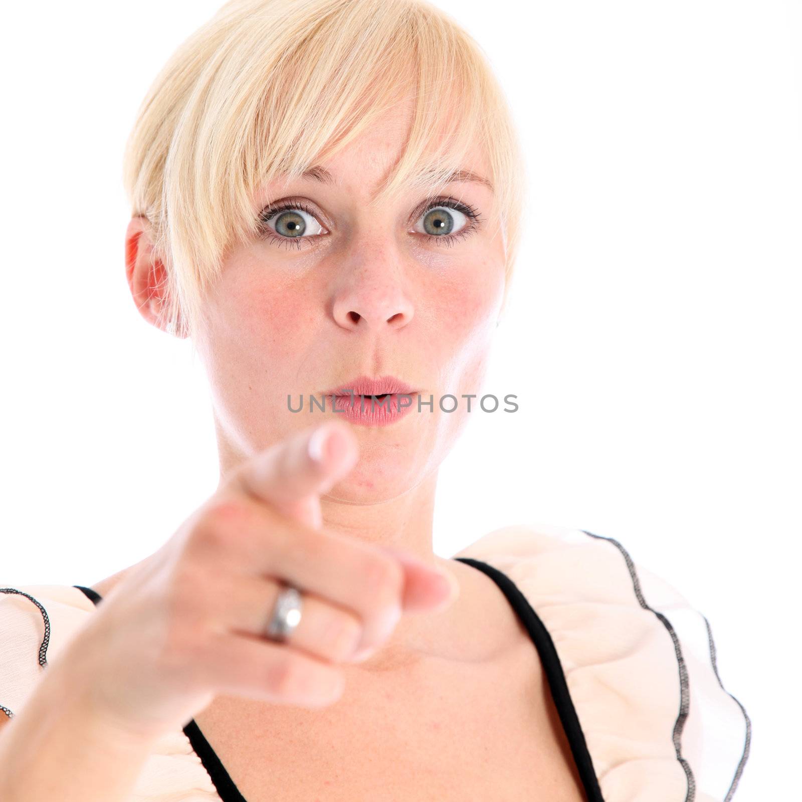 Shocked young woman pointing her finger at camera - isolated on white 