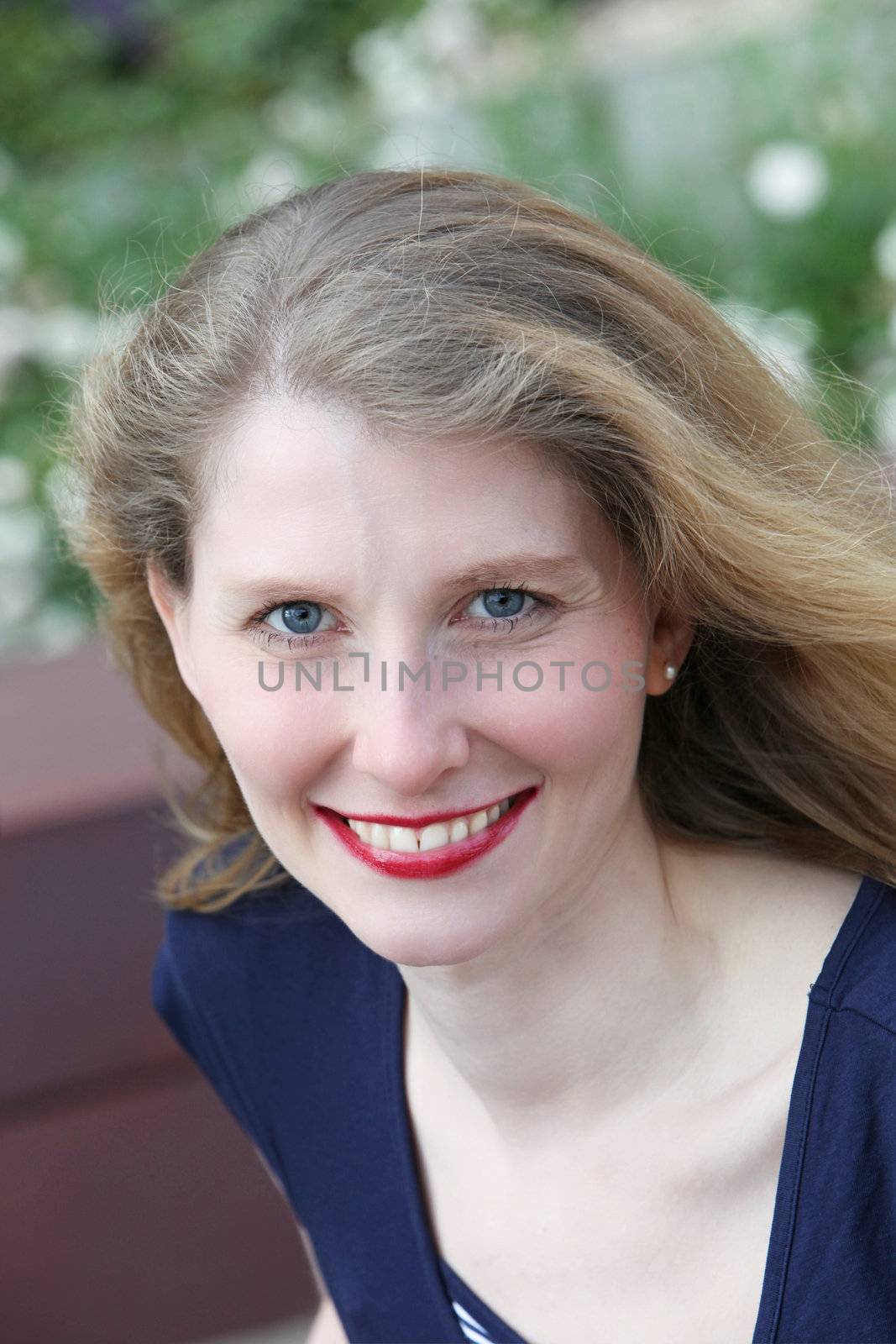 Attractive middle-aged woman with a wide friendly smile looking up at the camera 