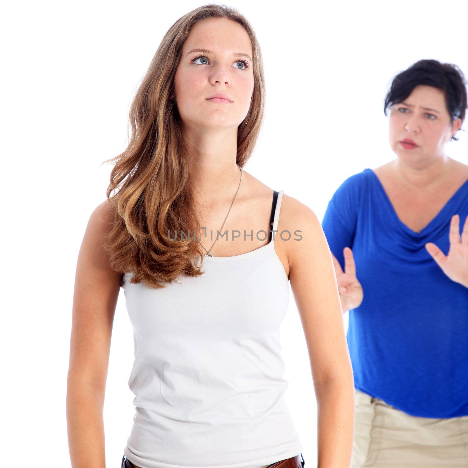 Mother arguing with her daughter who has her head held high with a tight lipped expression of defiance Mother arguing with her daughter who has her head held high with a tight lipped expression of defiance