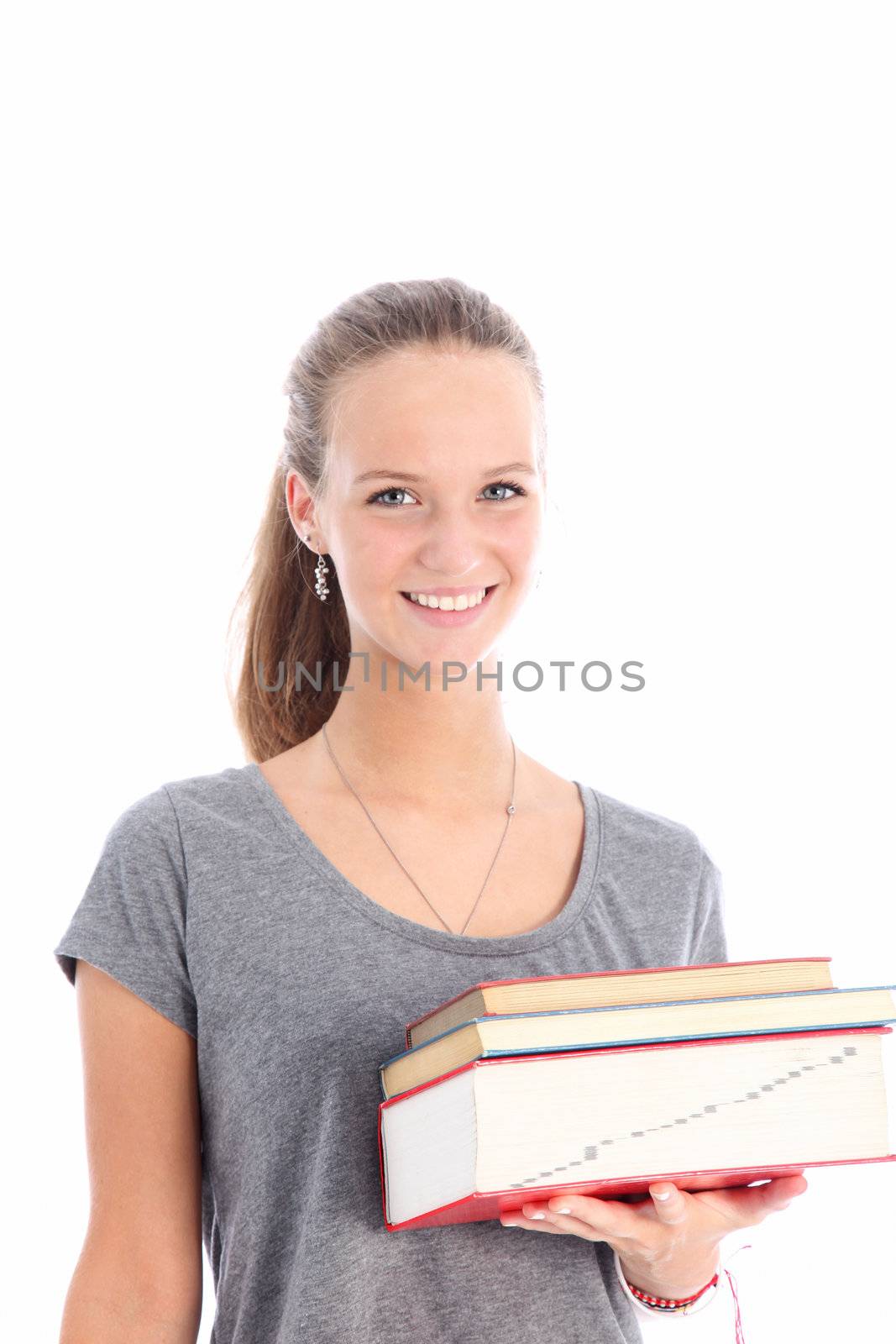 Happy young female student carrying her textbooks in her hand as she proceeds to class in a quest for knowledge and a better eduction Smiling female student holding bunch of books - islated on white 