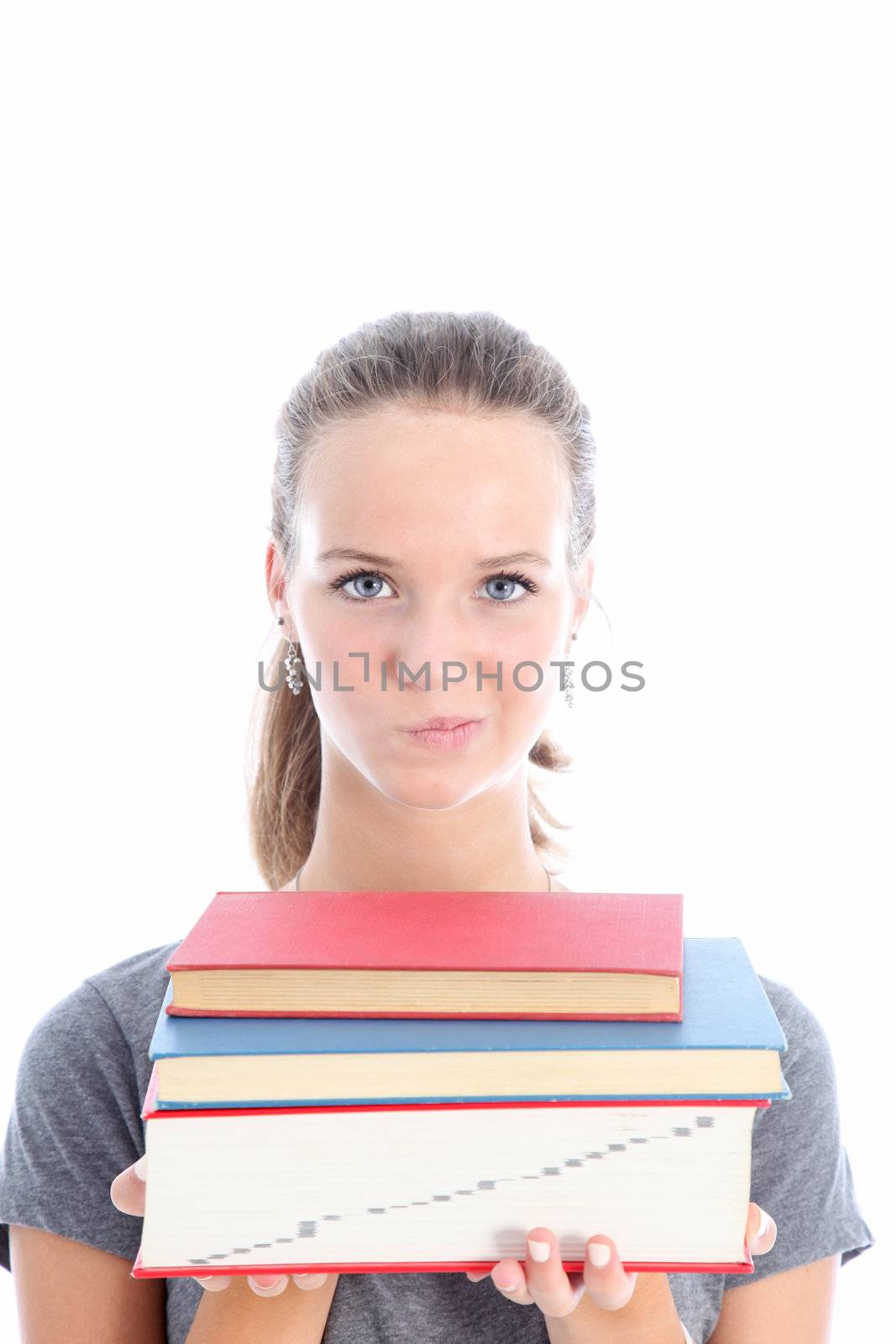 Attractive teenage student with a quizzical expression carrying a pile of textbooks as she wonders whether she has made the right choice for her studies and whether she will be able to cope Attractive teenage student with a quizzical carrying a pile of textbooks as she wonders whether she has made the right choice for her studies and whether she will be able to cope 