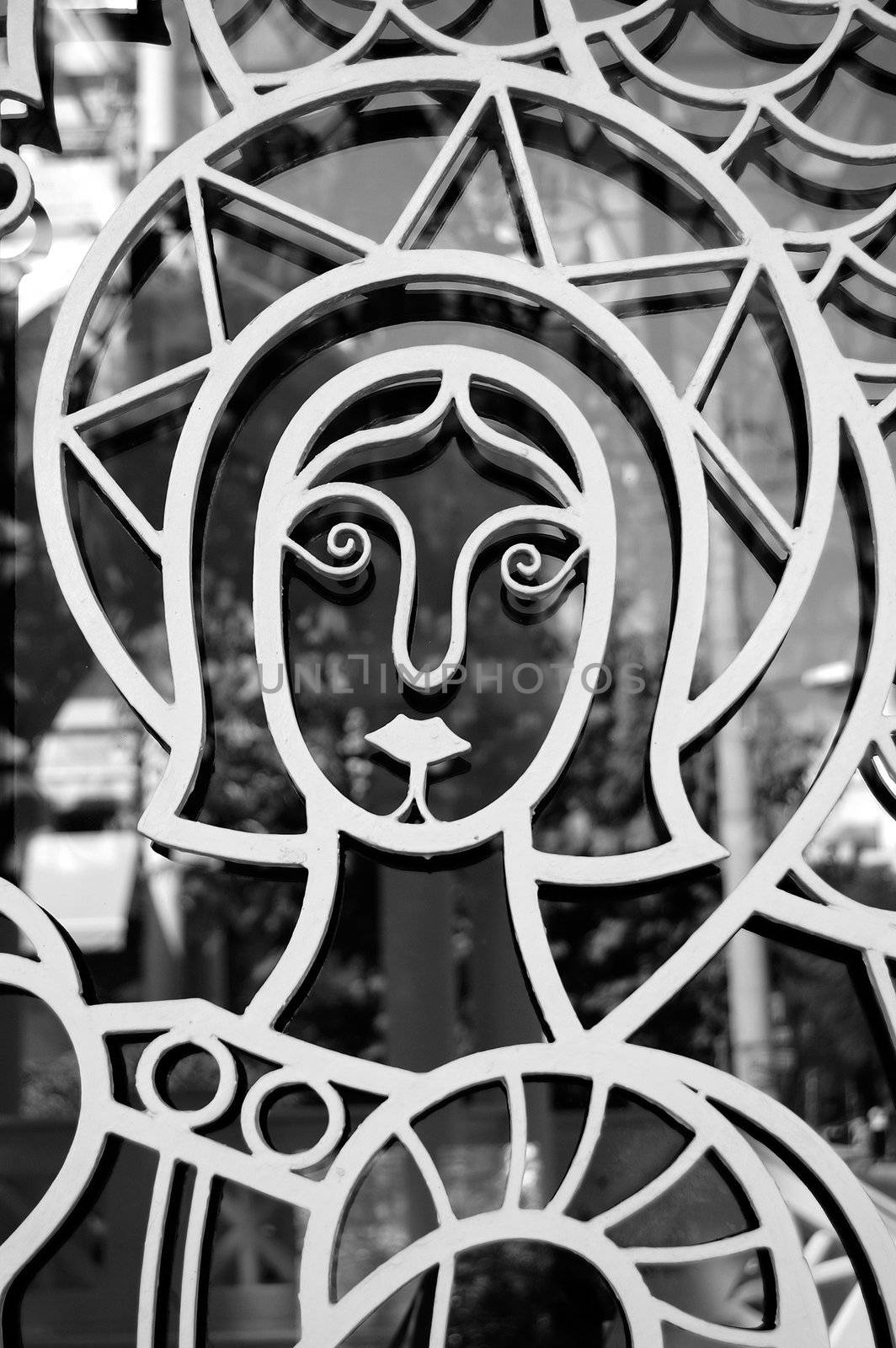 Saint figure on church door detail. Religious icon and light reflections on glass.