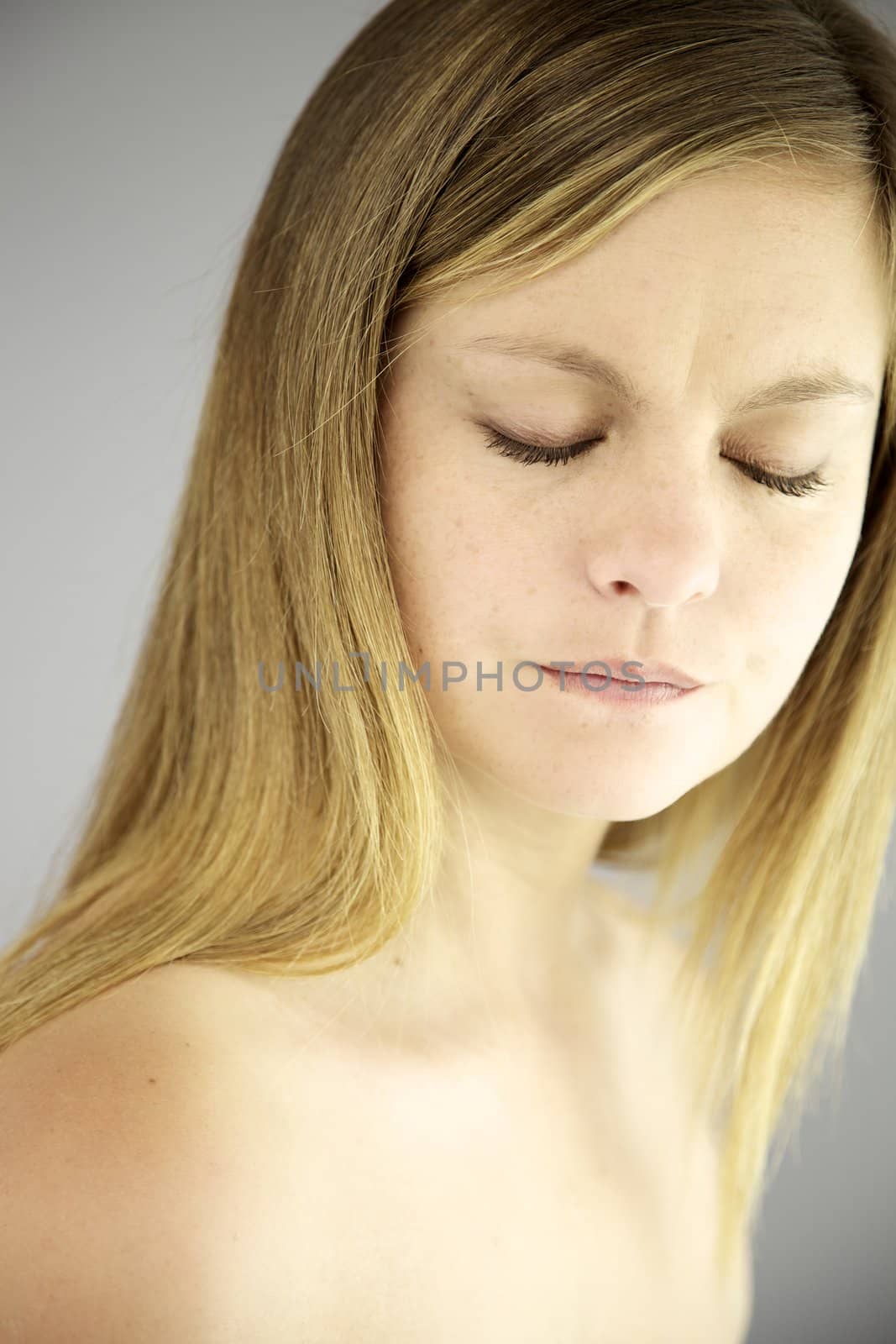 Sad young woman with her eyes closed and suffering expression