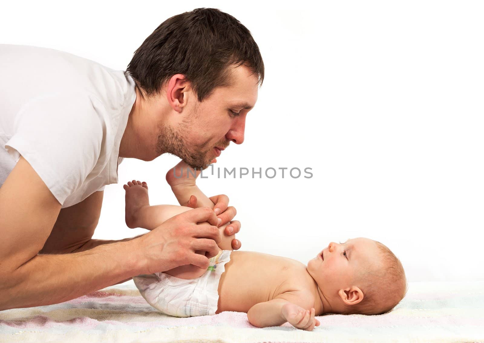 Young Caucasian father playing with baby son over white background