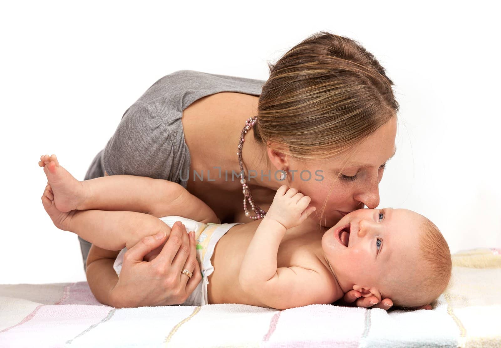 Young Caucasian woman kissing her baby son over white background