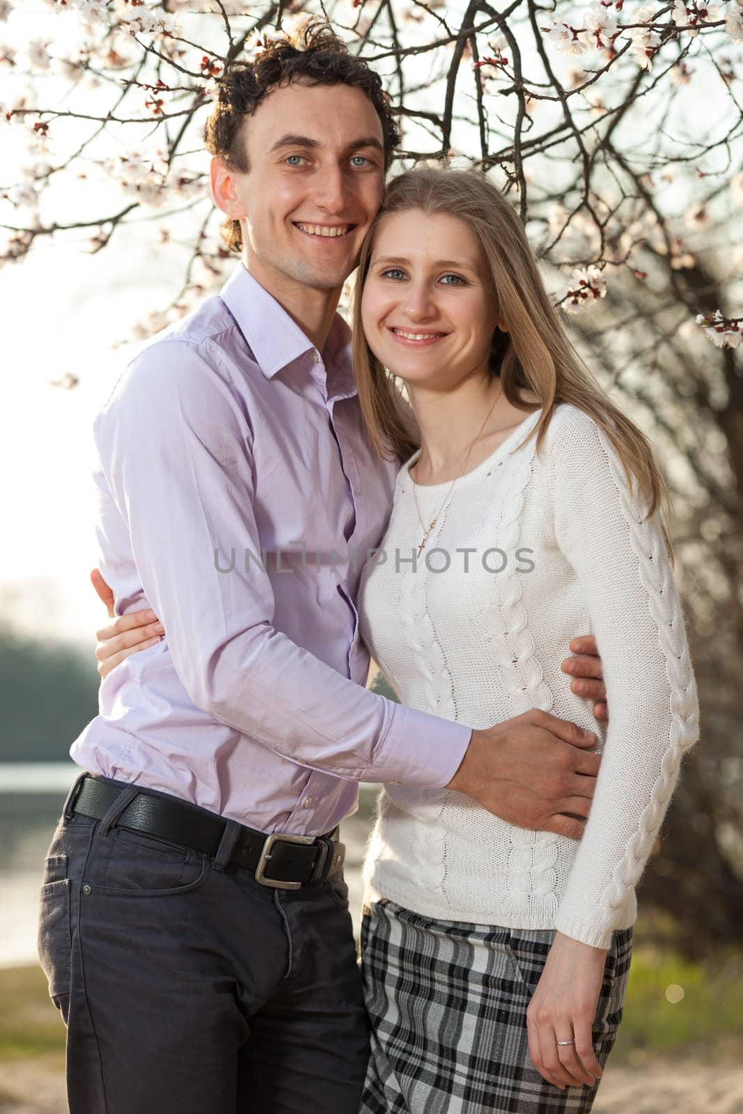 Young romantic couple in spring blossom by photobac