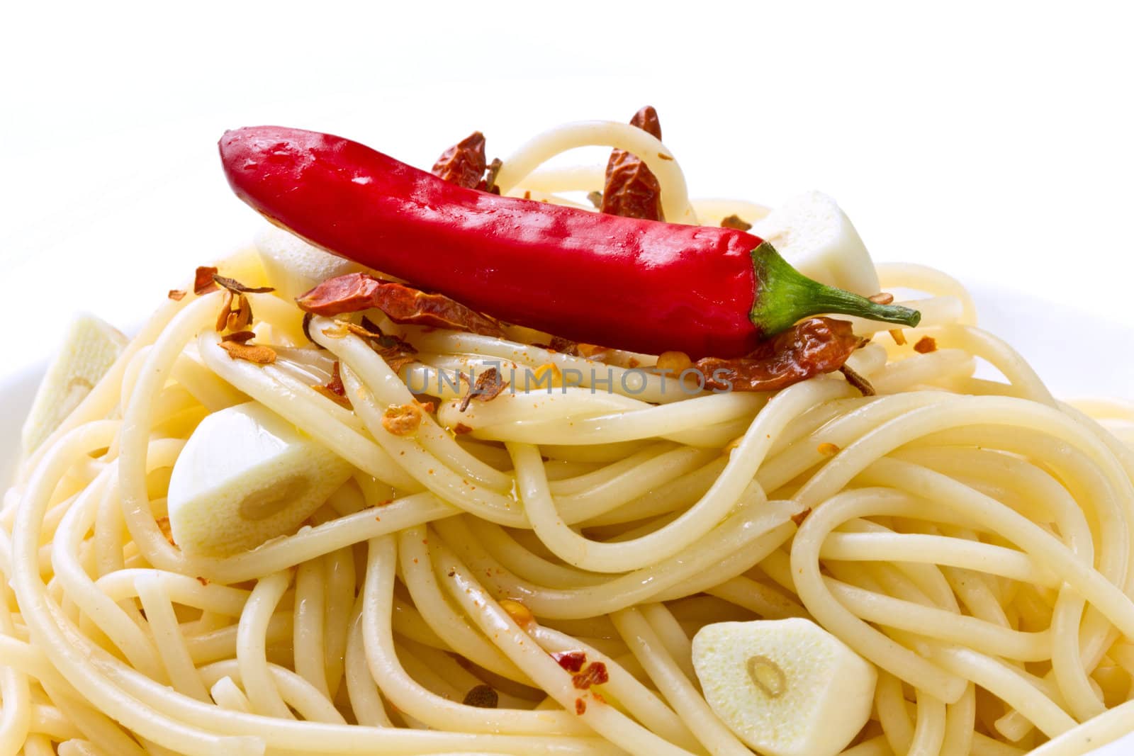 pasta garlic olive oil and red chili pepper closeup on a white dish